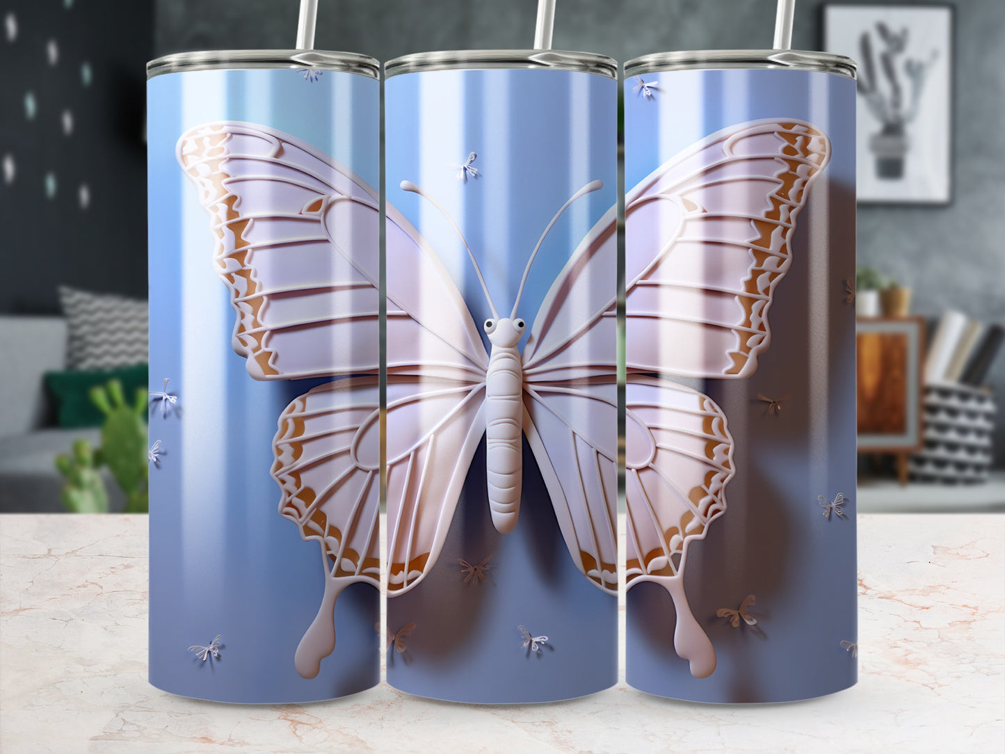 Three tumblers with iridescent butterfly designs and blue backgrounds.