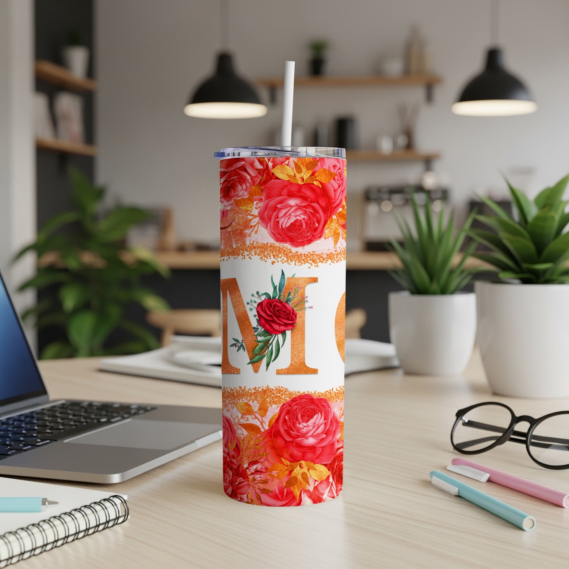 Mom tumbler with roses and sparkle accents on a desk.