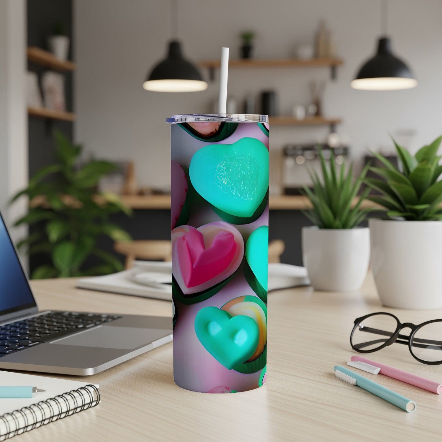 Pink and teal heart pattern on a white skinny tumbler with a straw.