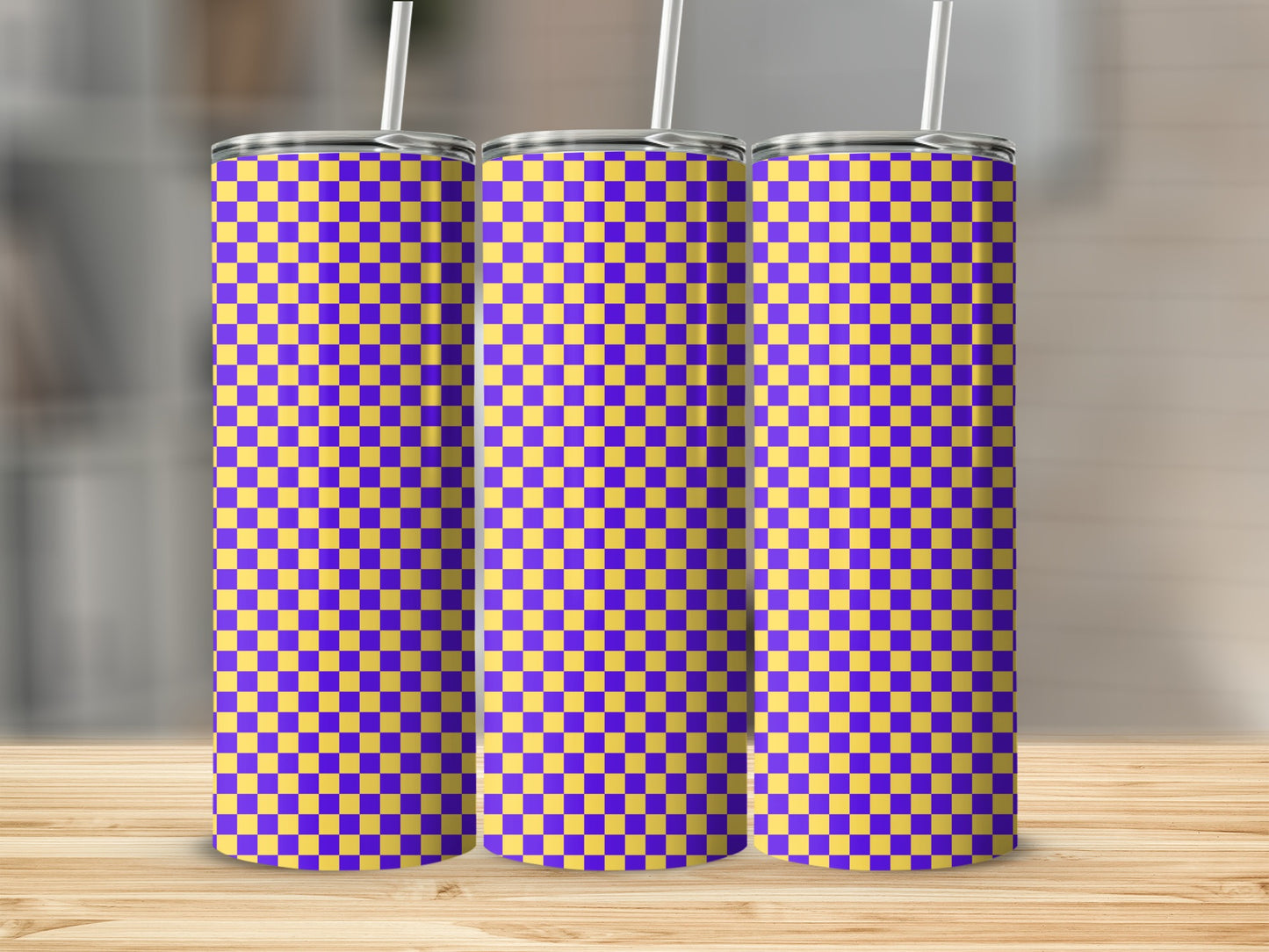 Three tall tumblers with a purple and yellow checkerboard pattern on a wooden surface.
