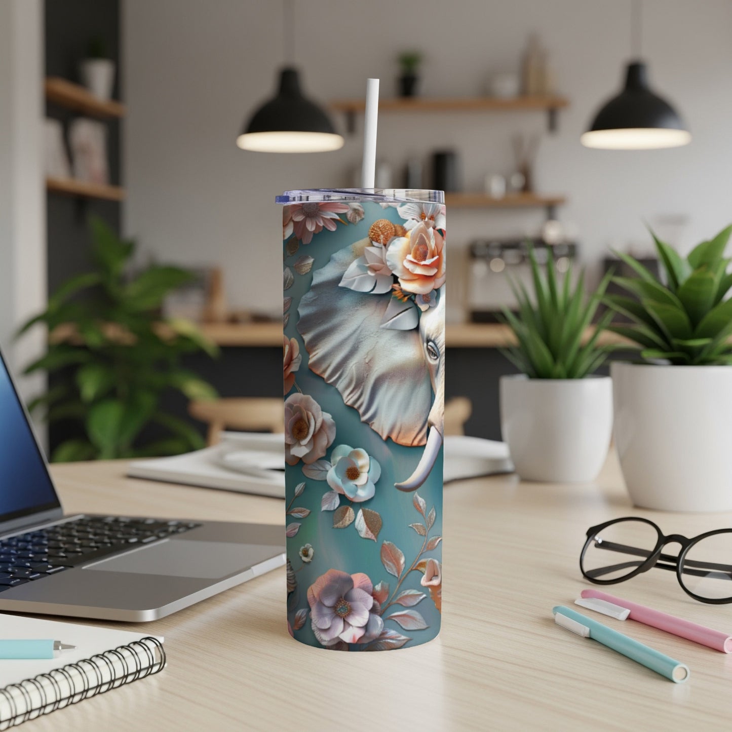 Teal skinny tumbler with floral elephant design and straw.