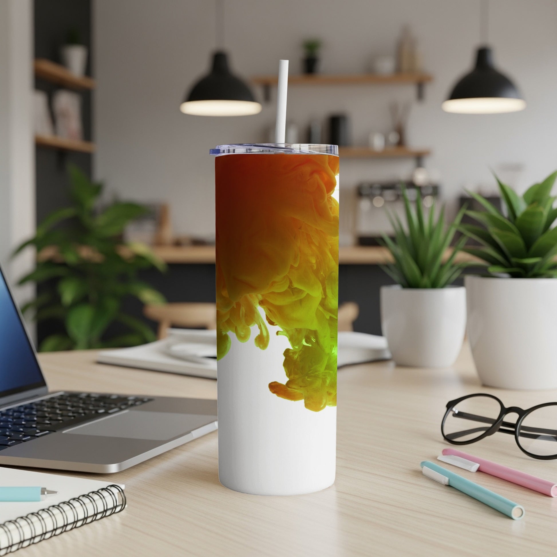White tumbler with swirling orange and green liquid art design.