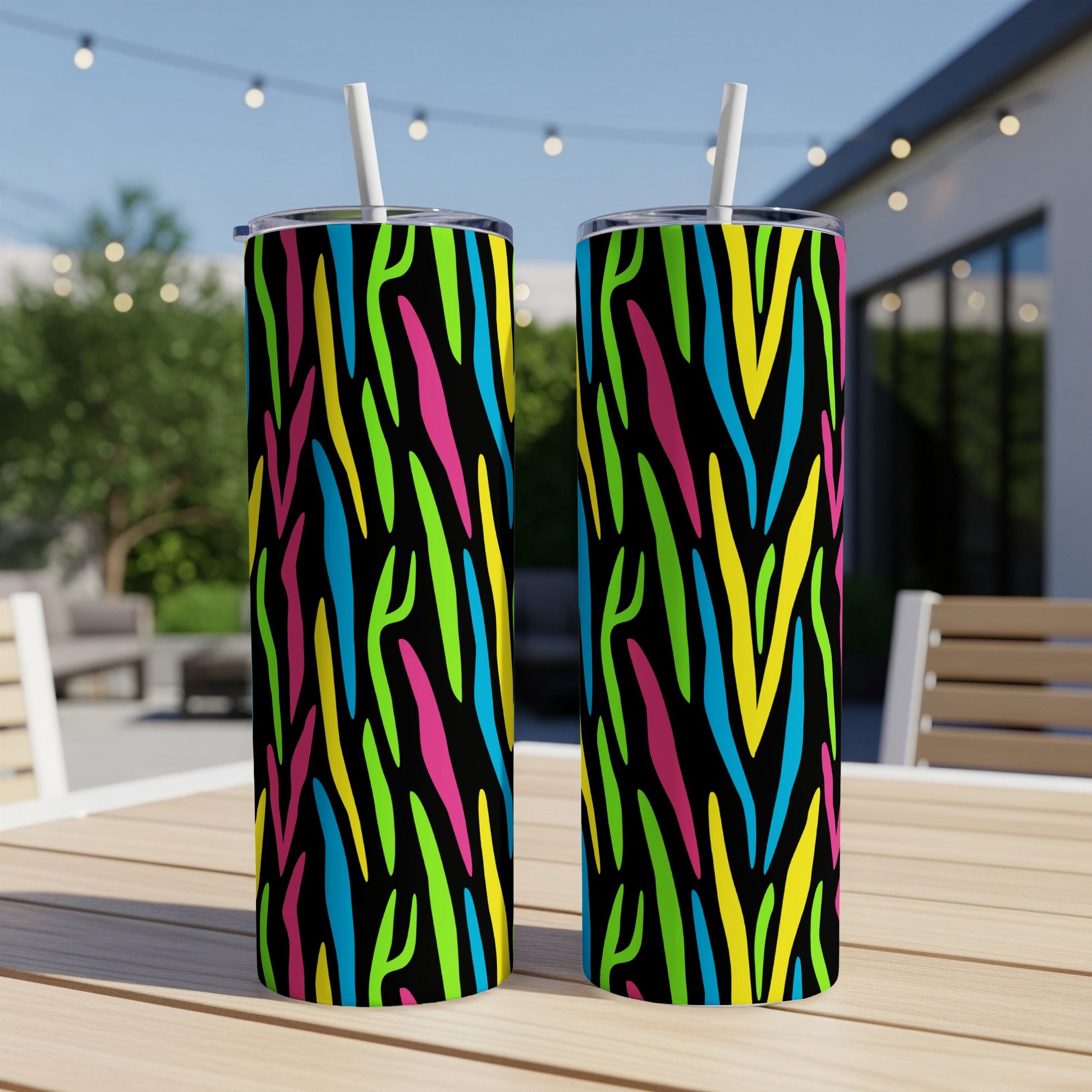 Two tumblers with a neon zebra stripe pattern on a wooden table.