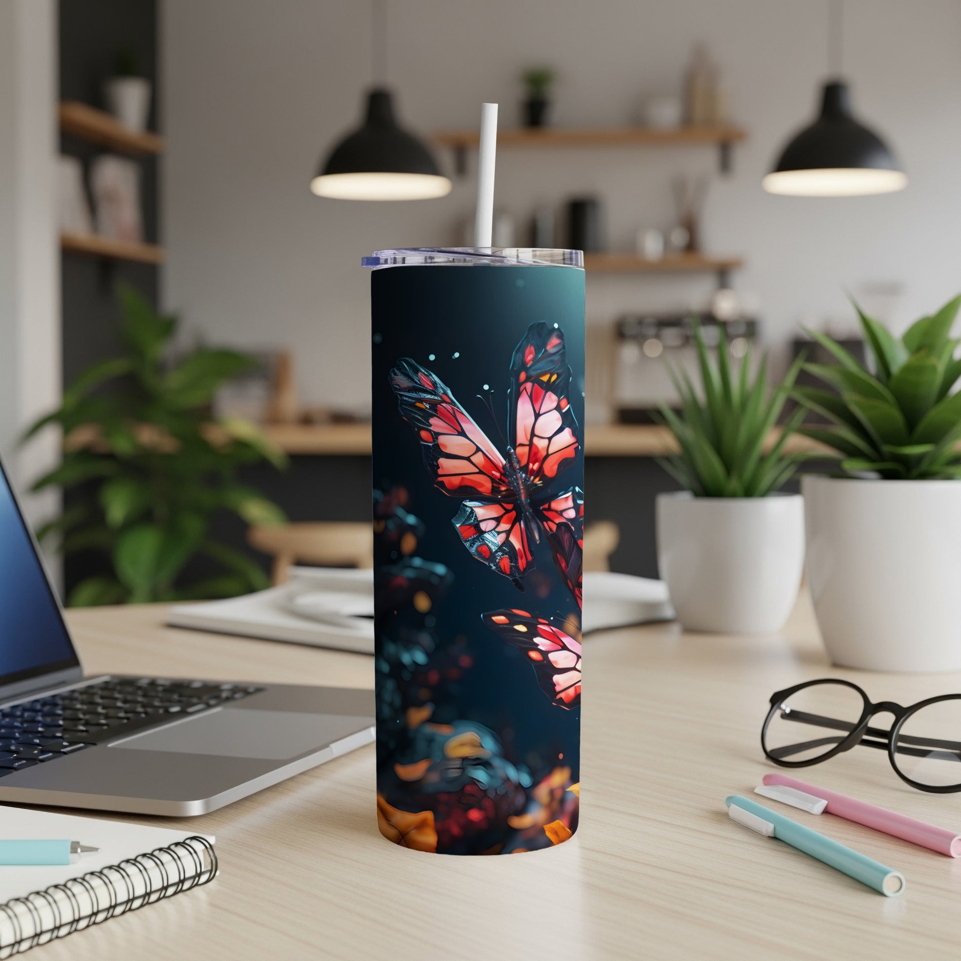 Tumbler with a colorful butterfly design and straw, on a desk.