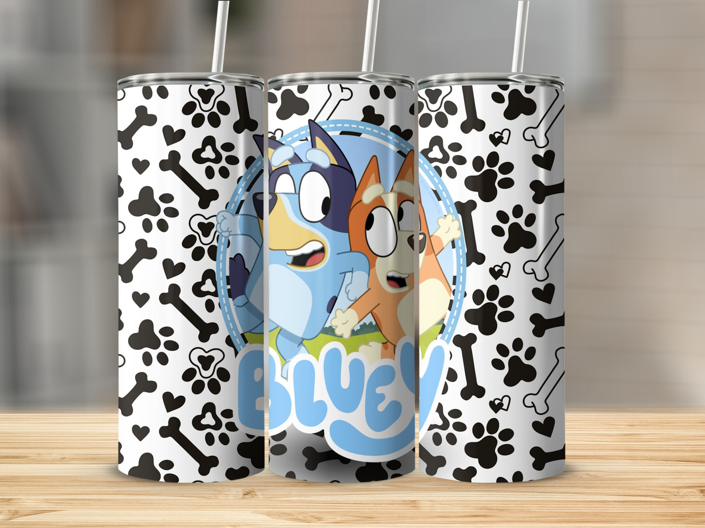 Bluey and Bingo cartoon dogs on a black and white paw print pattern tumbler.