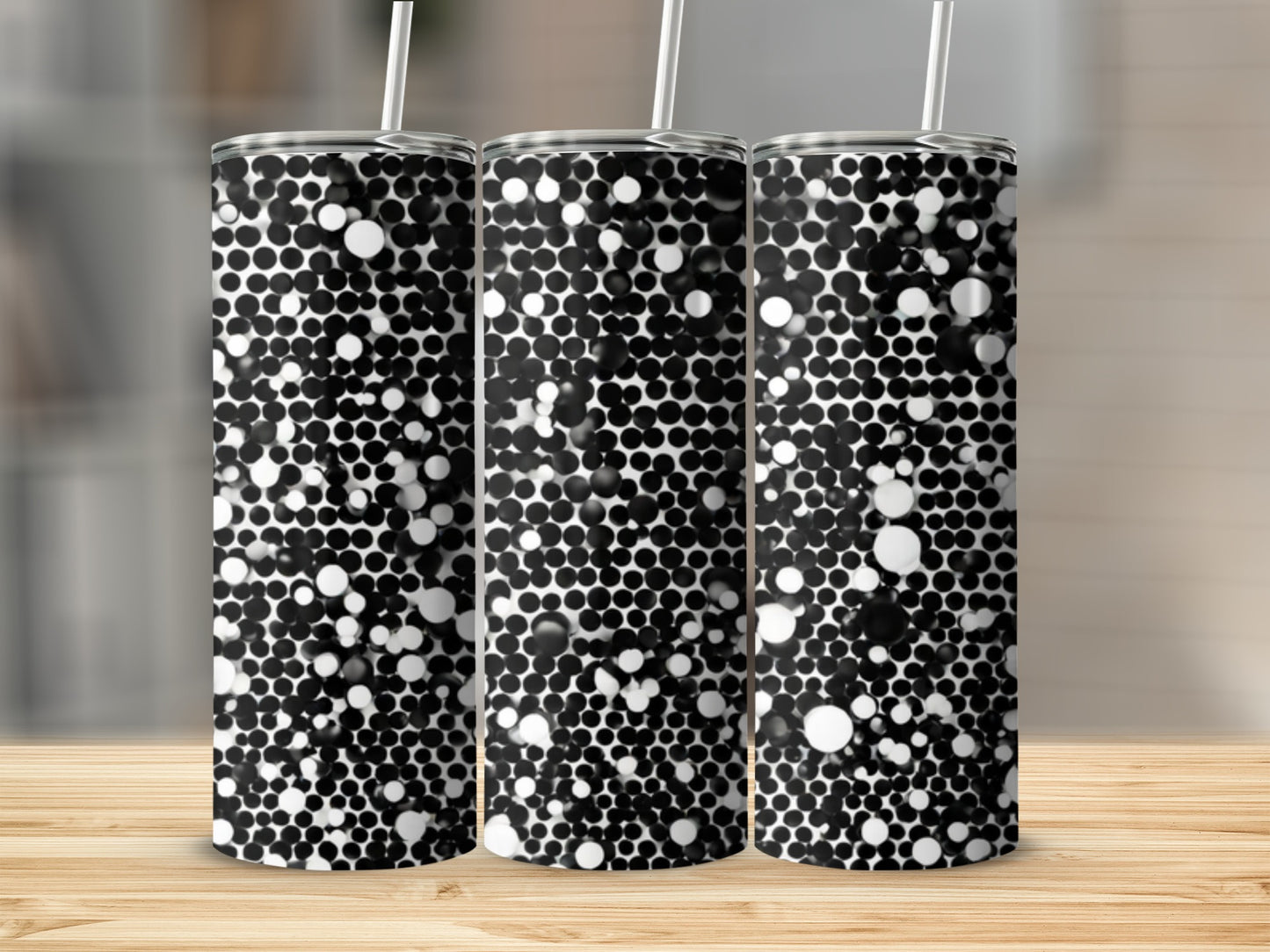 Three tumblers with a black and white bubble pattern on a wooden surface.