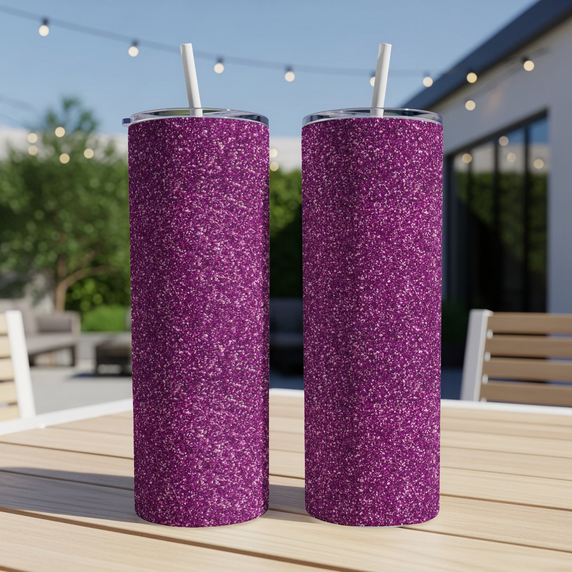 Two purple glitter tumblers with white straws sit on a wooden table.