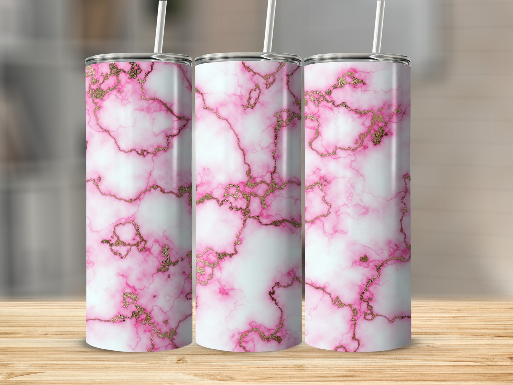 Three tumblers with pink and gold marble pattern on a wooden surface.