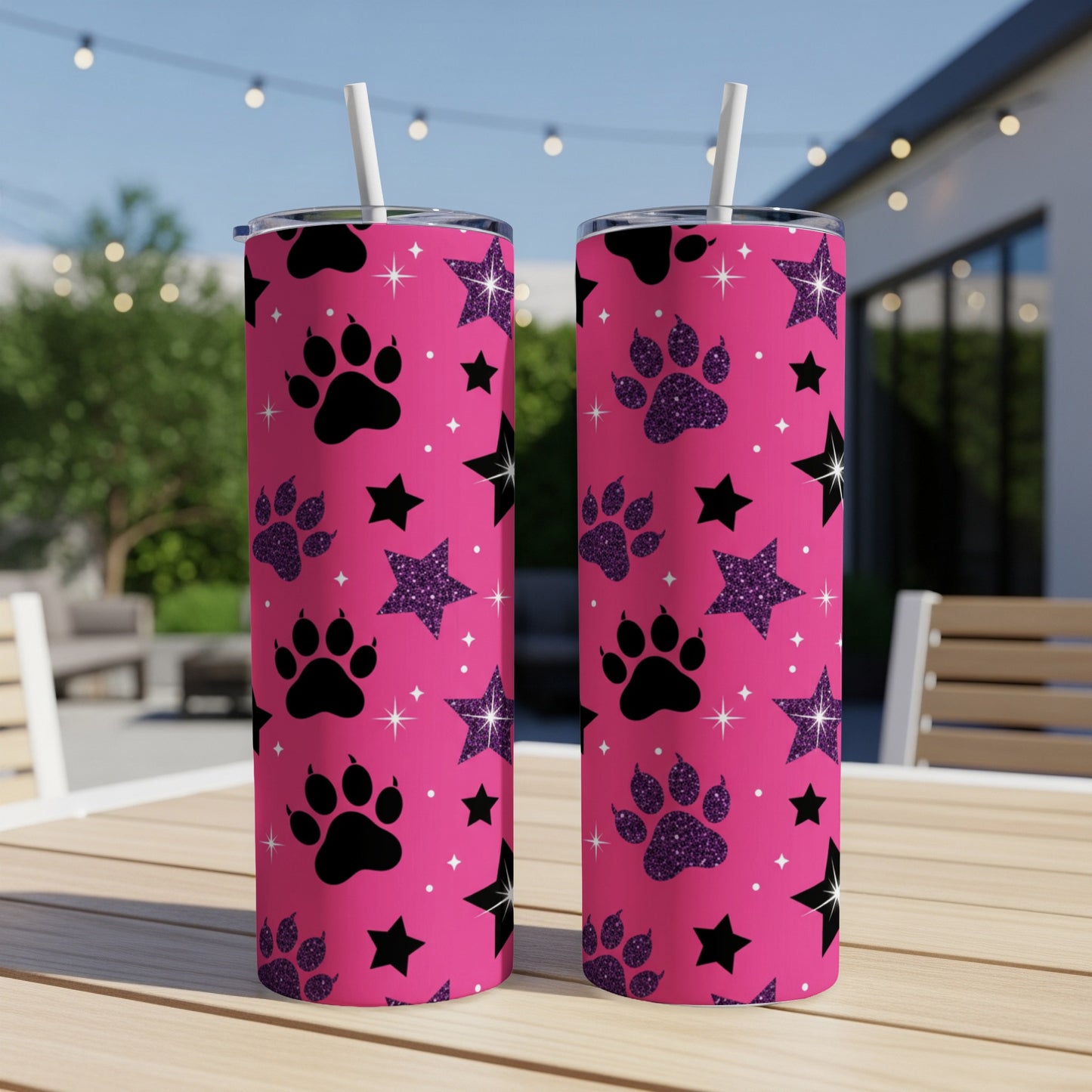 Two pink tumblers with paw prints and glitter stars, on a wooden table.