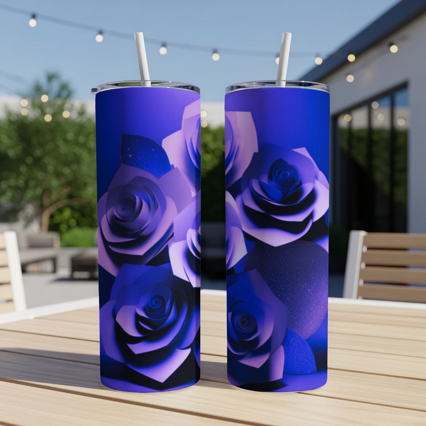 Two blue rose patterned tumblers with straws on a wooden table.