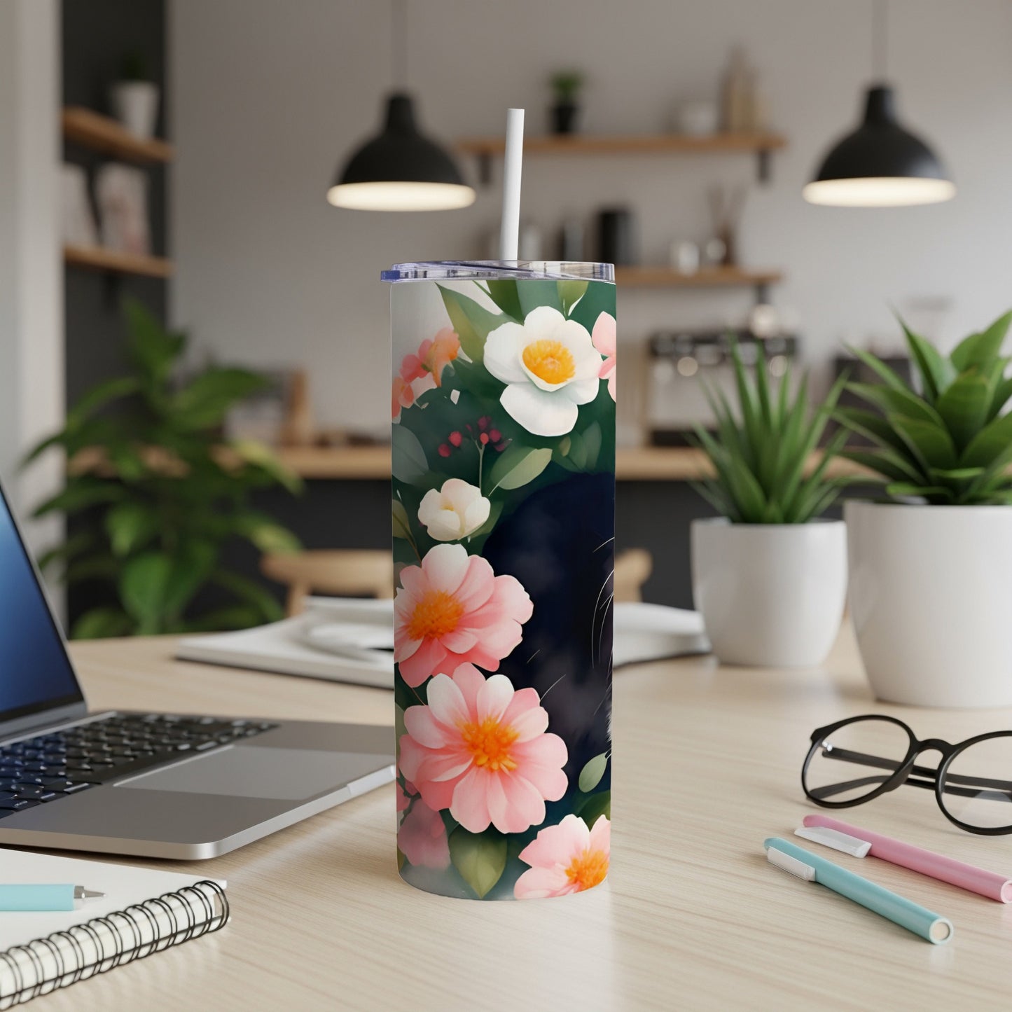 Black cat with pink and white flowers on a white floral tumbler.