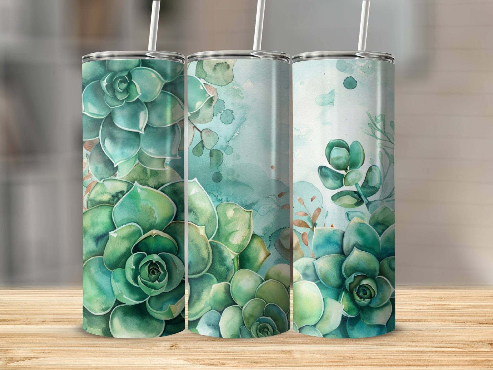 Three tall tumblers with green succulent designs on a wooden surface.
