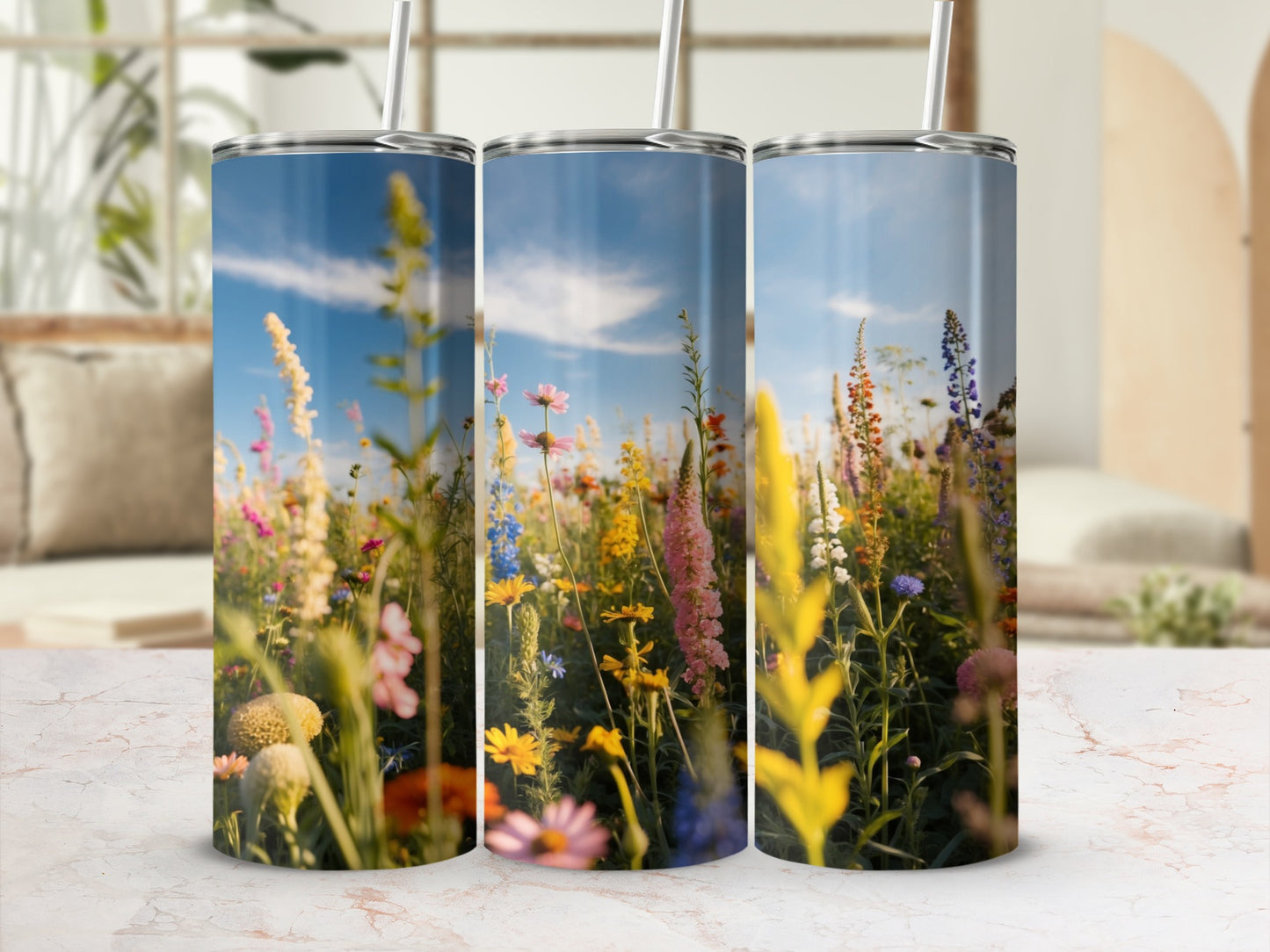 Three tumblers with a field of wildflowers against a blue sky.