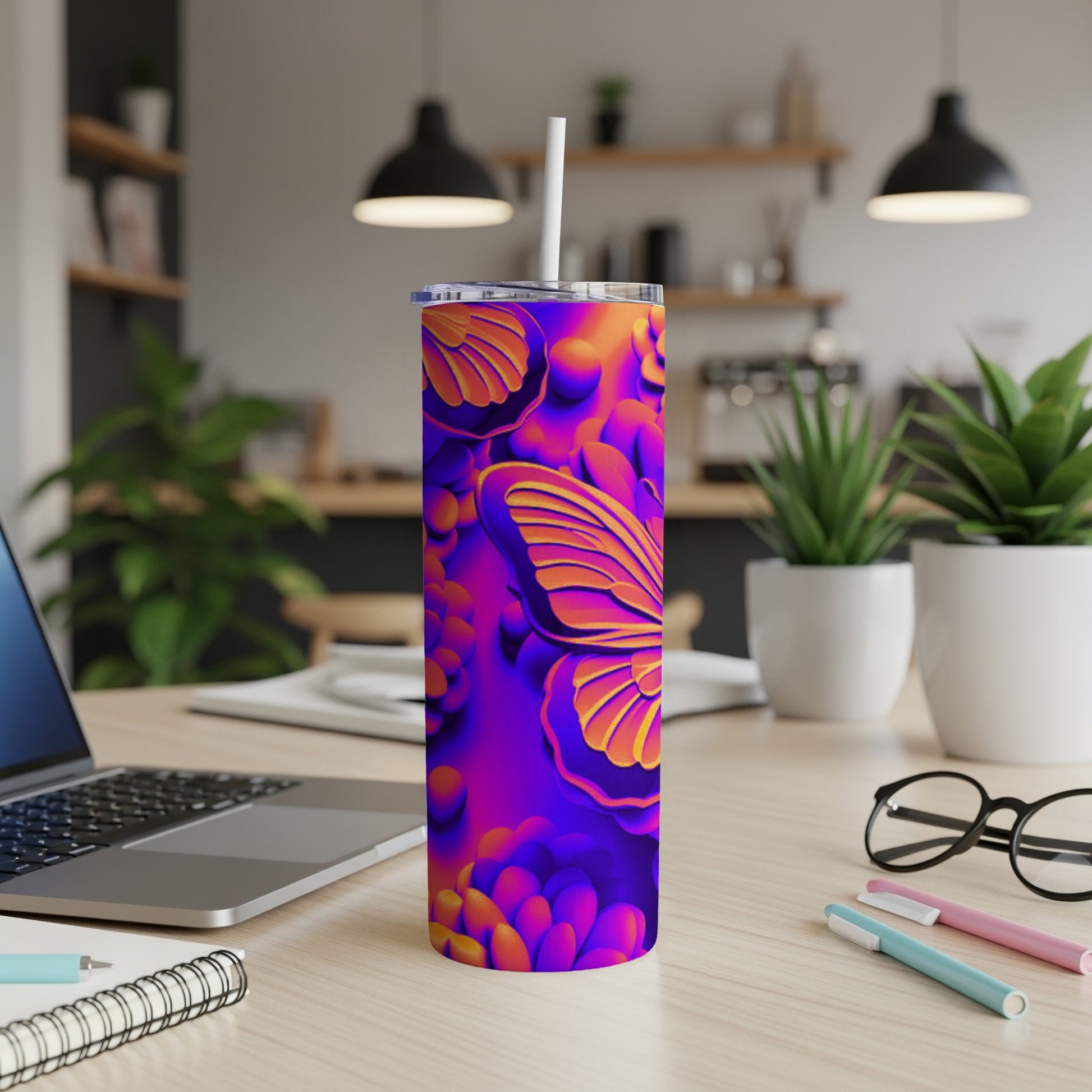 Purple and orange butterfly pattern on a tumbler with a straw, on a desk.