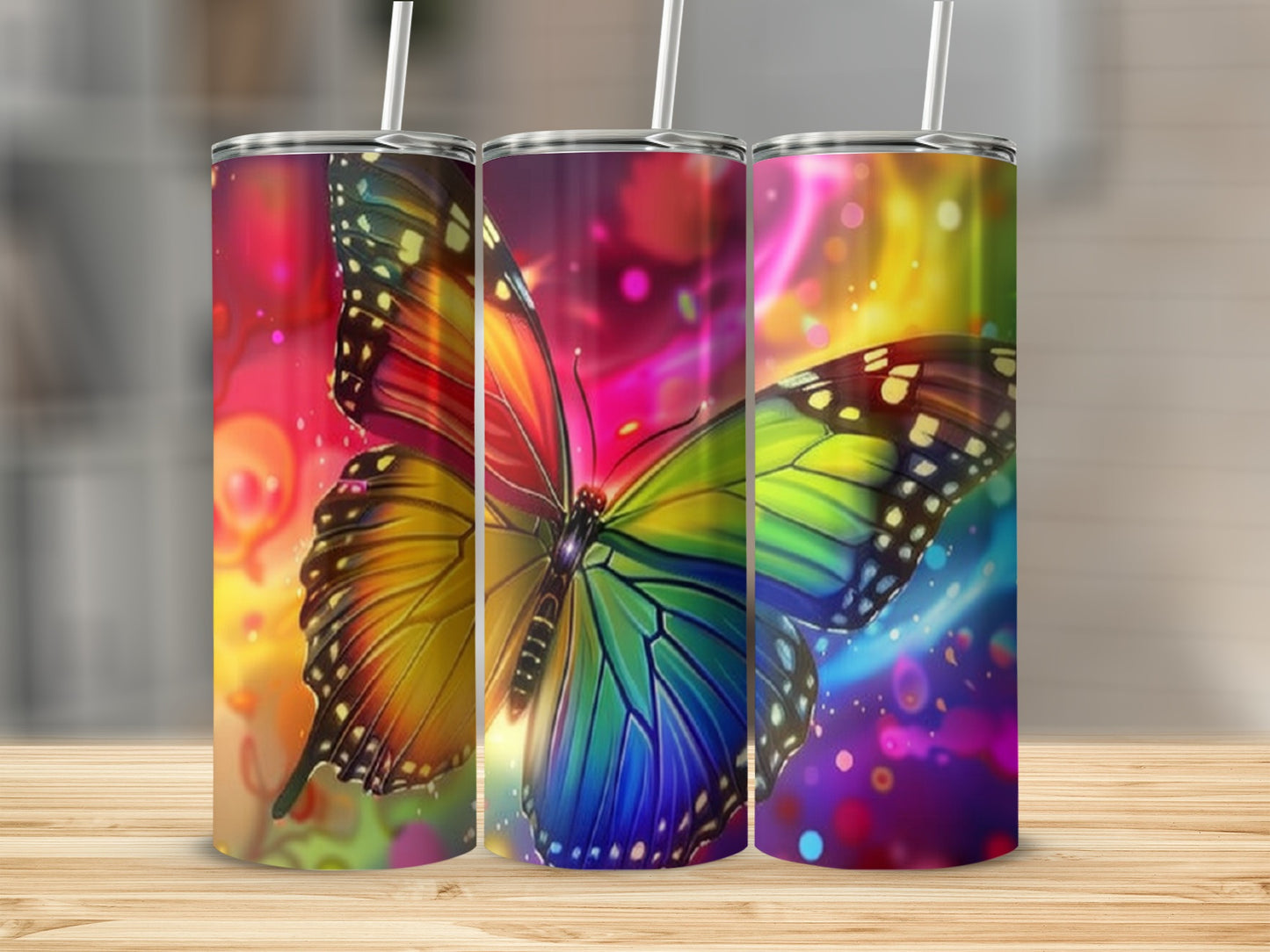 Three tumblers with colorful butterfly and abstract watercolor designs.