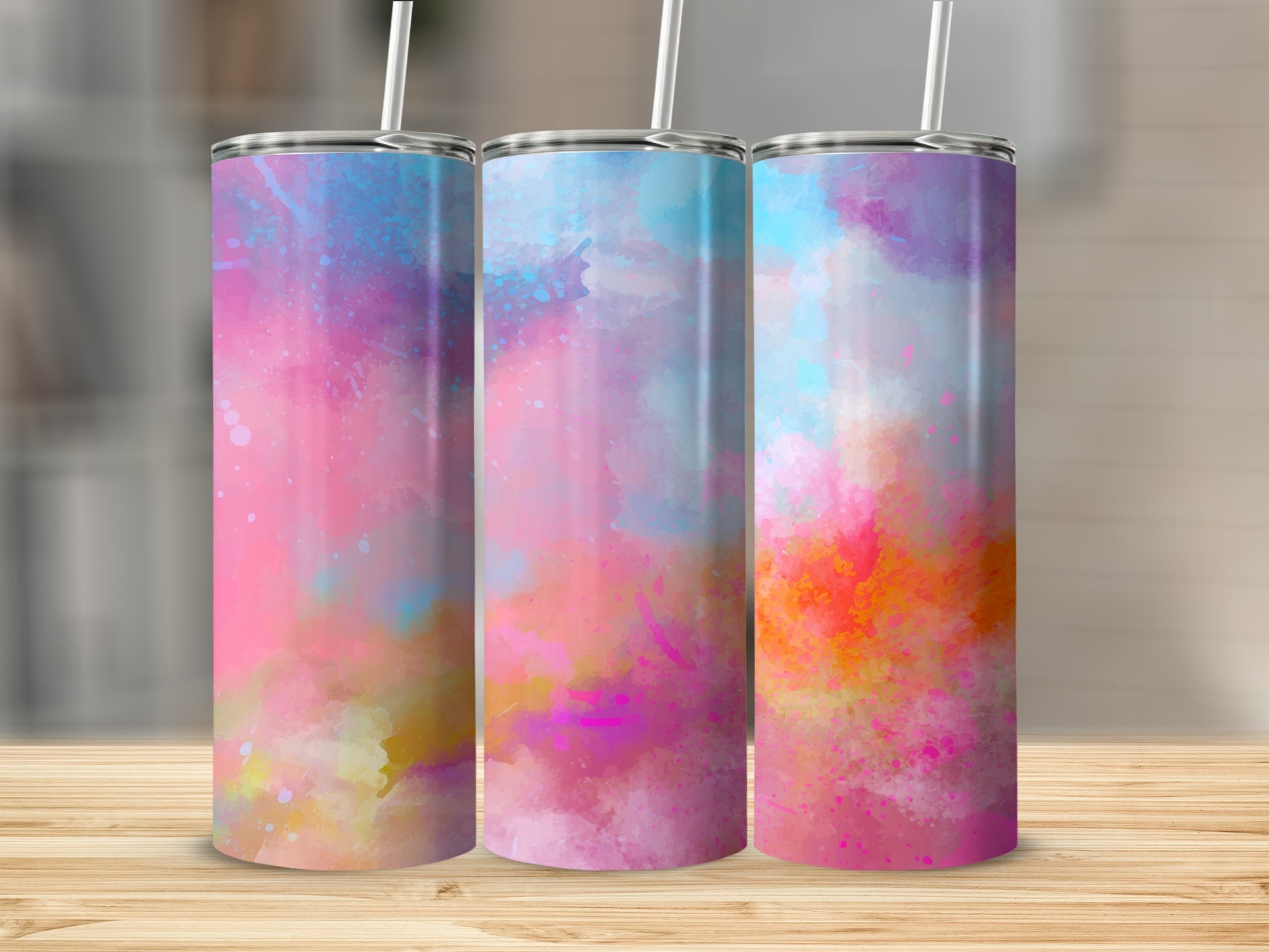 Three tumblers with colorful abstract watercolor designs and straws.
