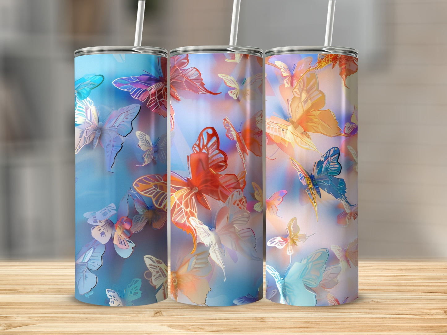 Three tumblers with colorful butterfly designs in blue, pink, and orange.