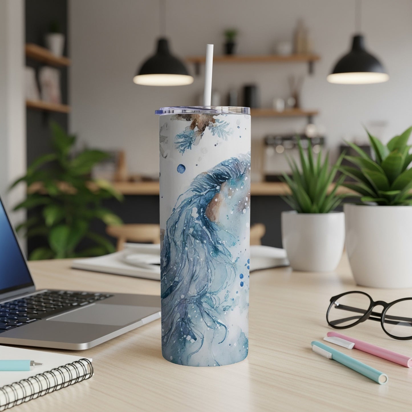 White tumbler with blue watercolor abstract design and straw.