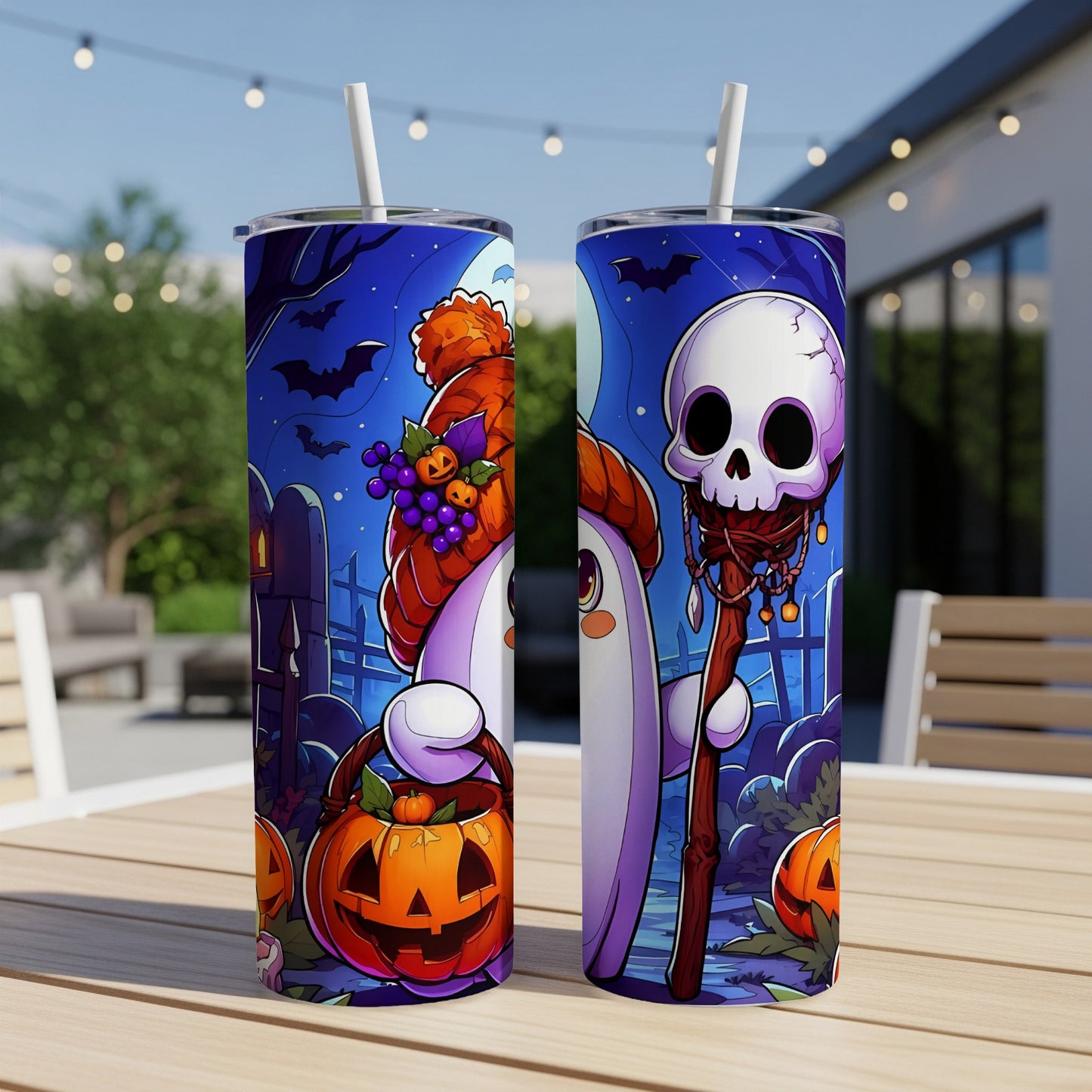 Two tumblers with Halloween ghost and skull designs on a table outdoors.
