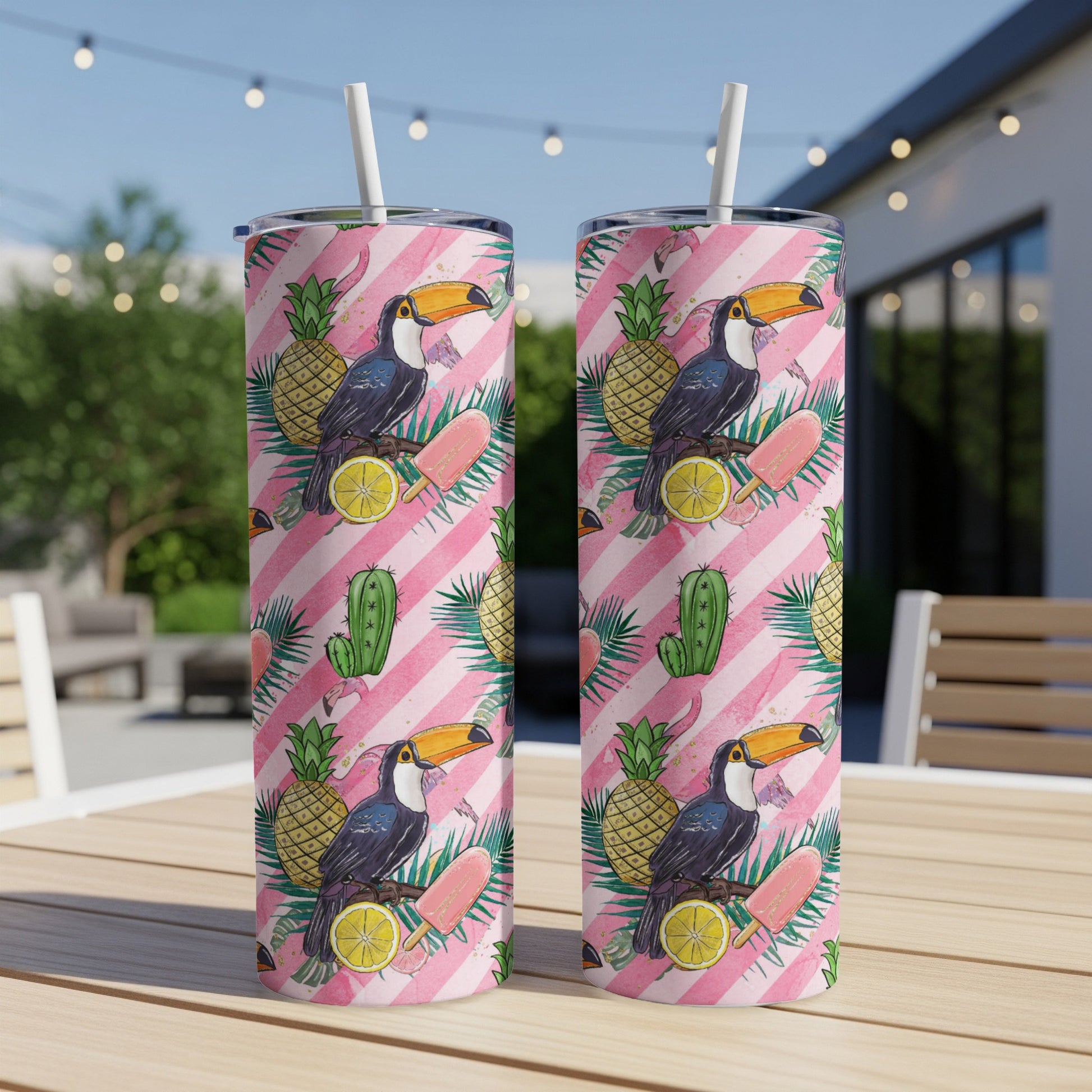 Two tall tumblers with a pink palm leaf and fruit pattern.