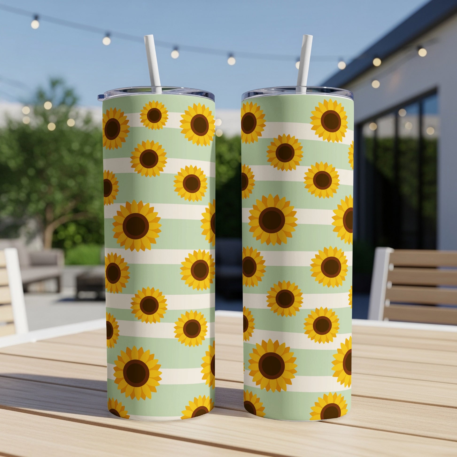 Two mint green tumblers with sunflower pattern and white striped detail.