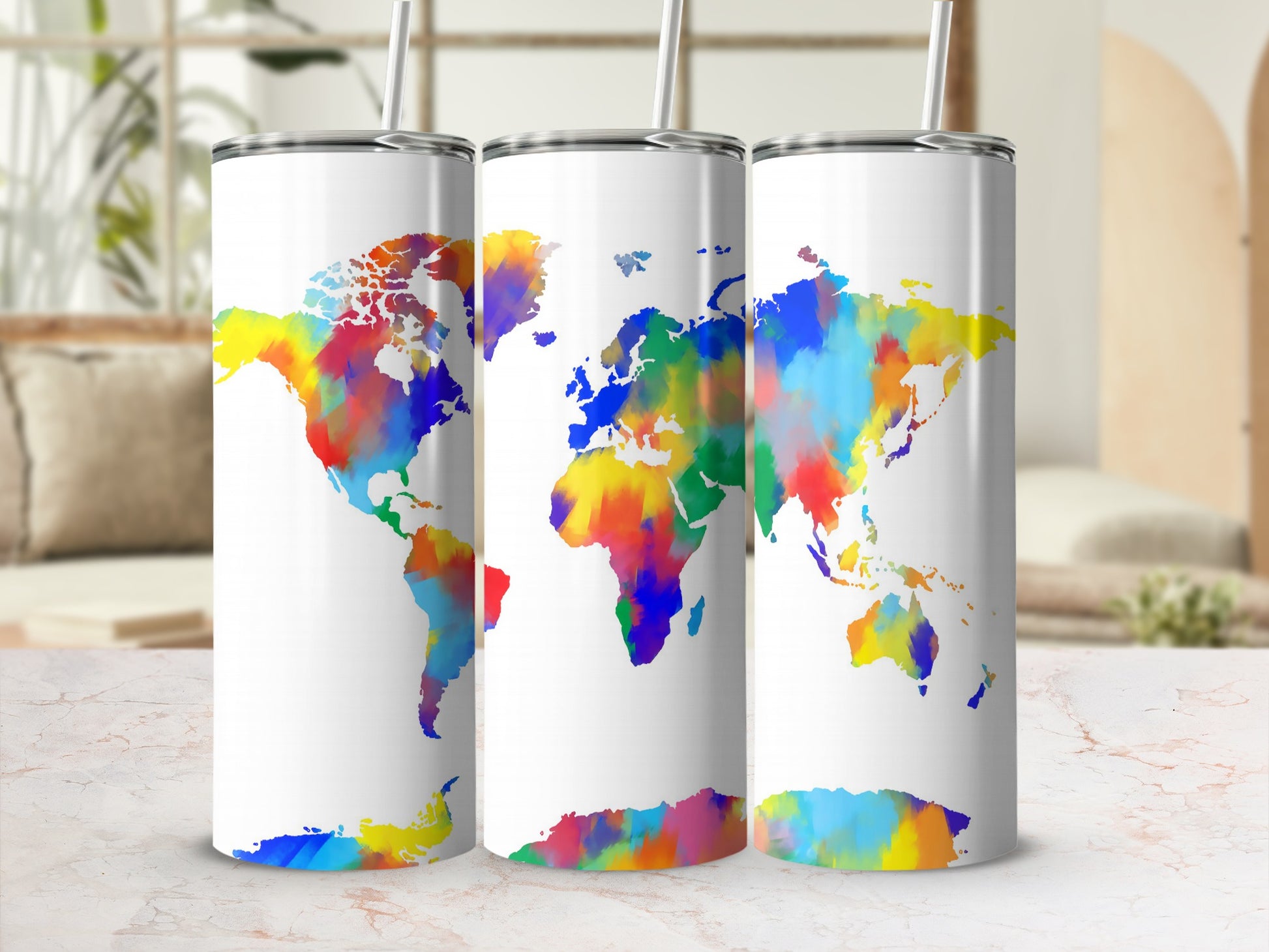 Three white tumblers with colorful watercolor world map designs and straws.