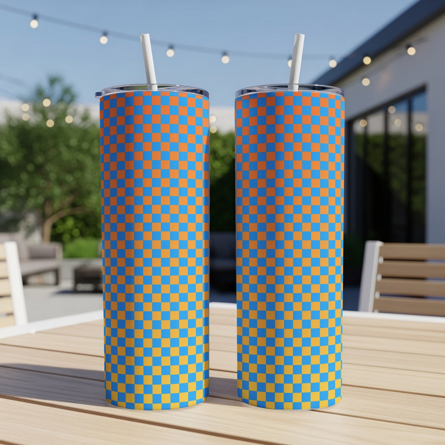 Two tall tumblers with an orange and blue checkered pattern stand on a wooden table.