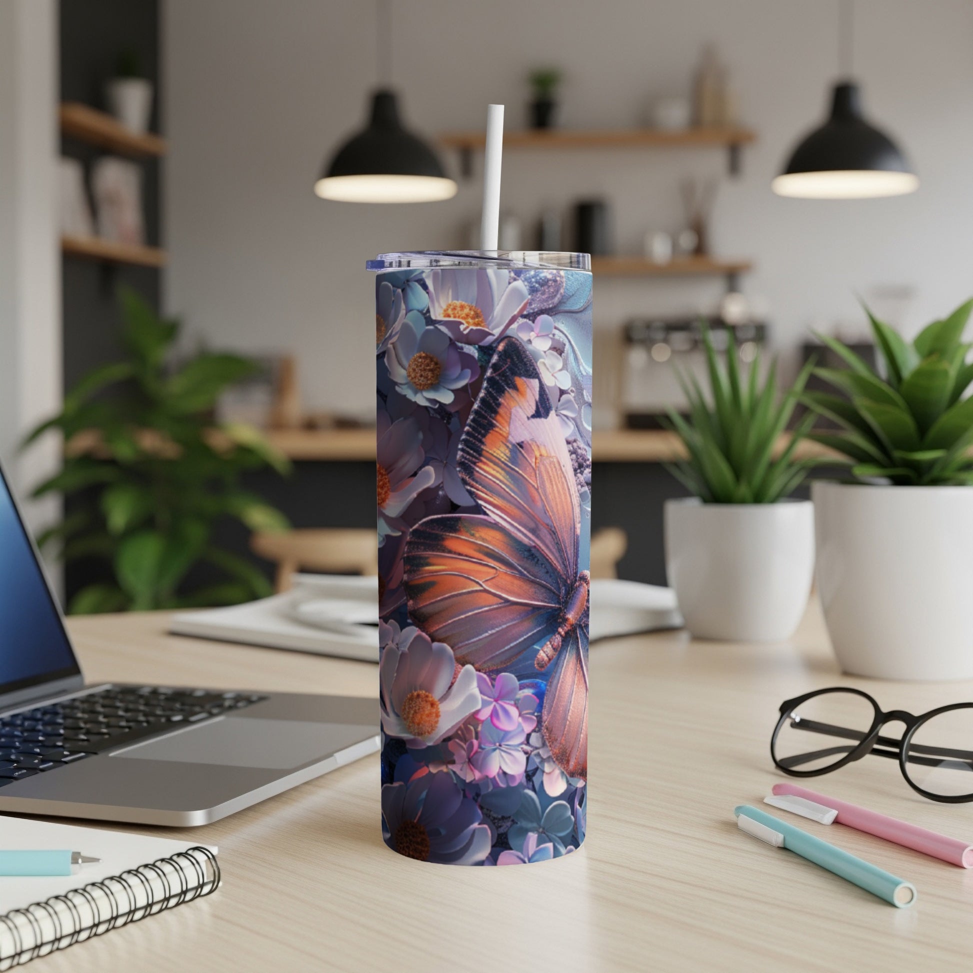 Tumbler with butterfly and floral design on a desk.