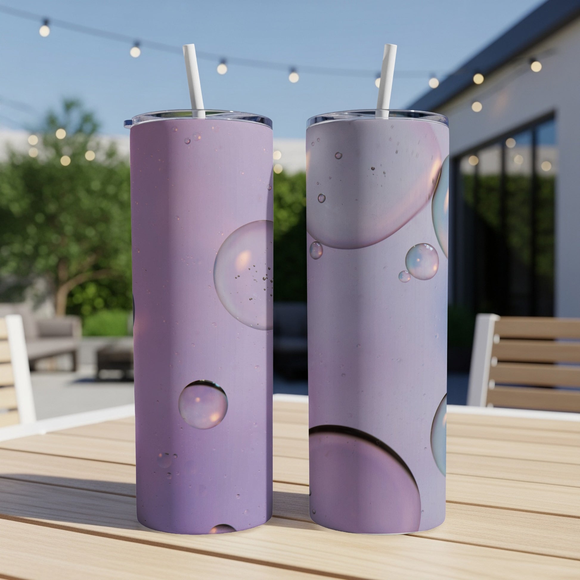 Two purple tumblers with bubble pattern on a table outdoors.