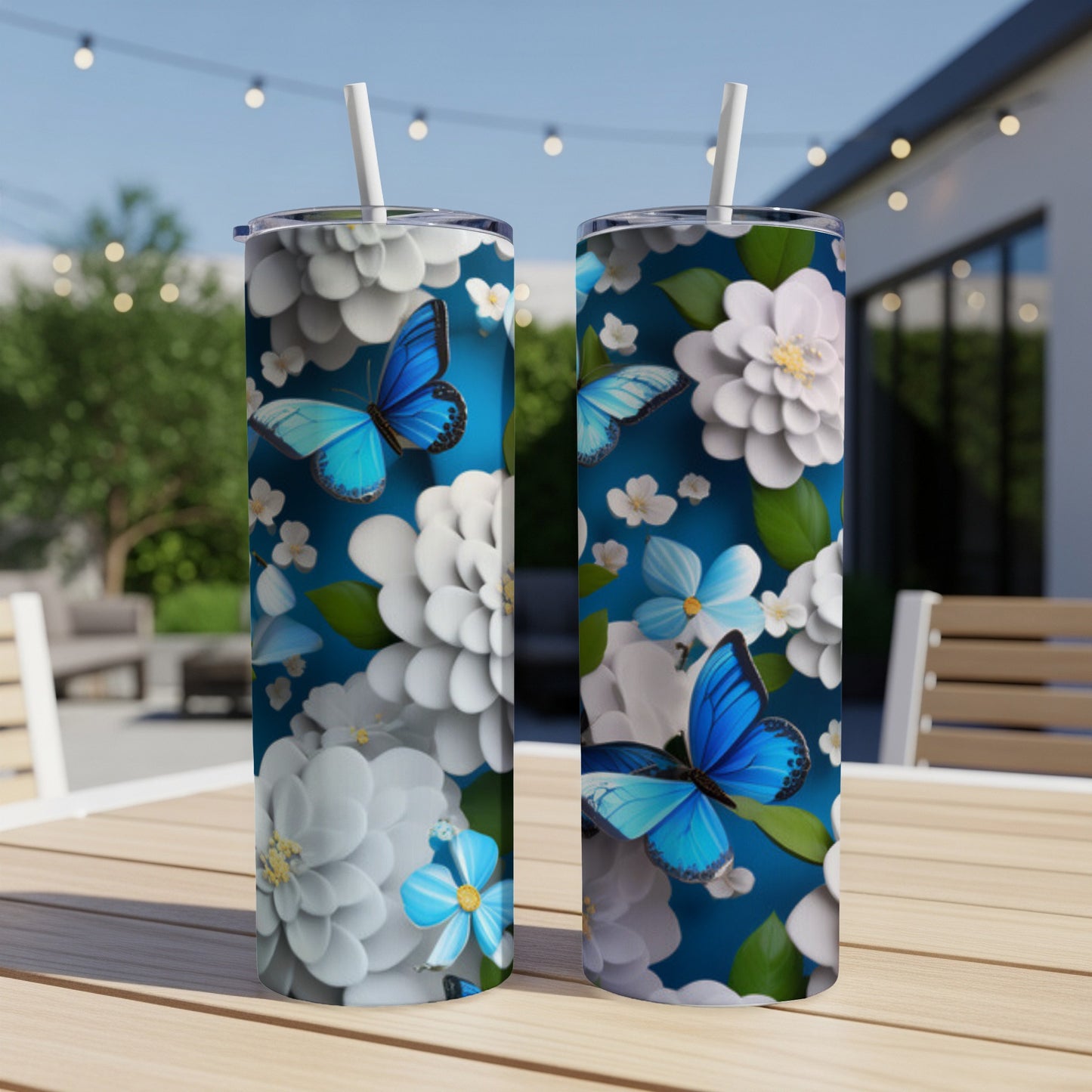 Blue butterflies and white flowers adorn two blue tumblers on a wooden table.