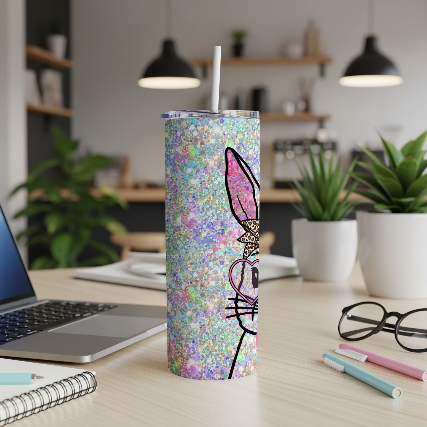 Glittery Easter bunny tumbler with straw on a desk.