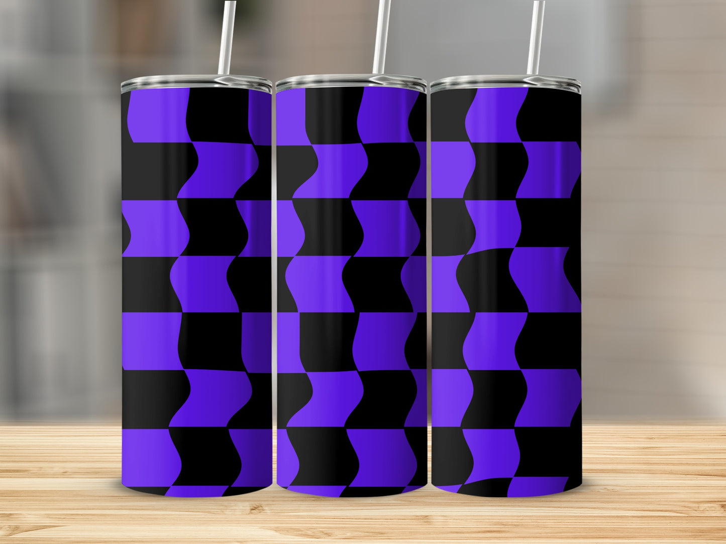 Three purple and black checkered tumblers with straws on a wooden surface.