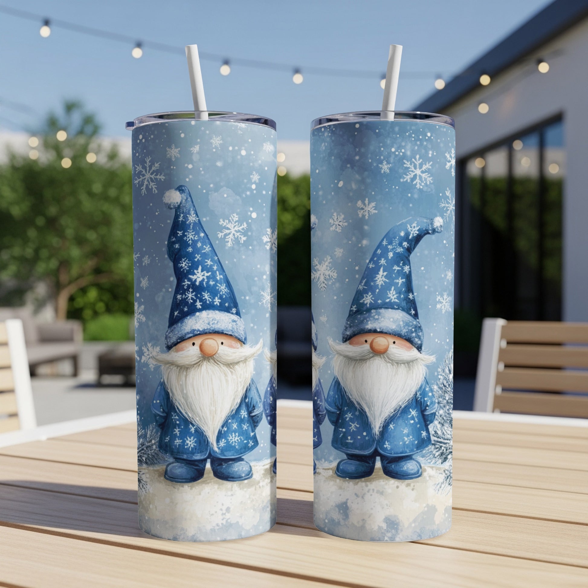 Two blue gnome tumblers with snow and pine trees in a backyard setting.