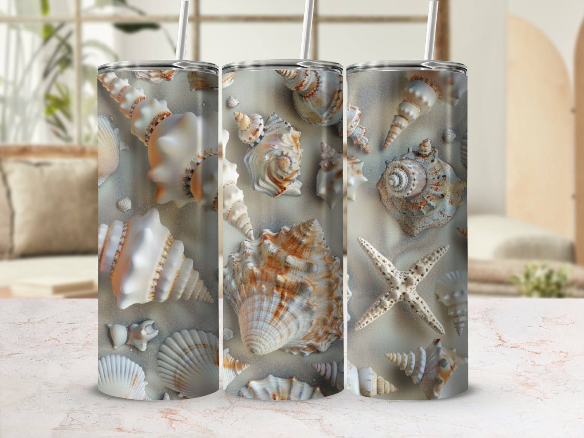 Three tall tumblers decorated with seashells and starfish on a sandy beach.