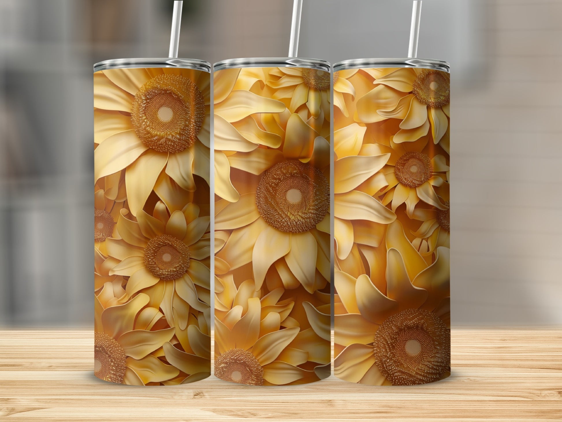 Three tumblers with a repeating sunflower floral pattern on a wooden surface.