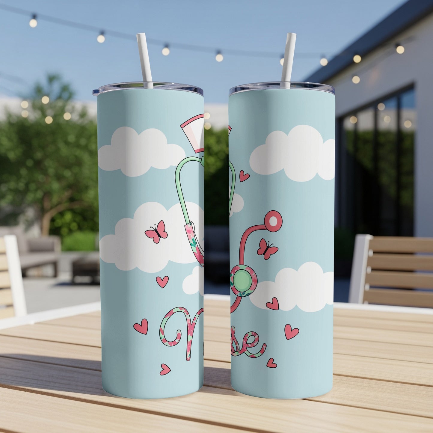 Two nurse-themed tumblers with stethoscope, hearts, and clouds on a table.