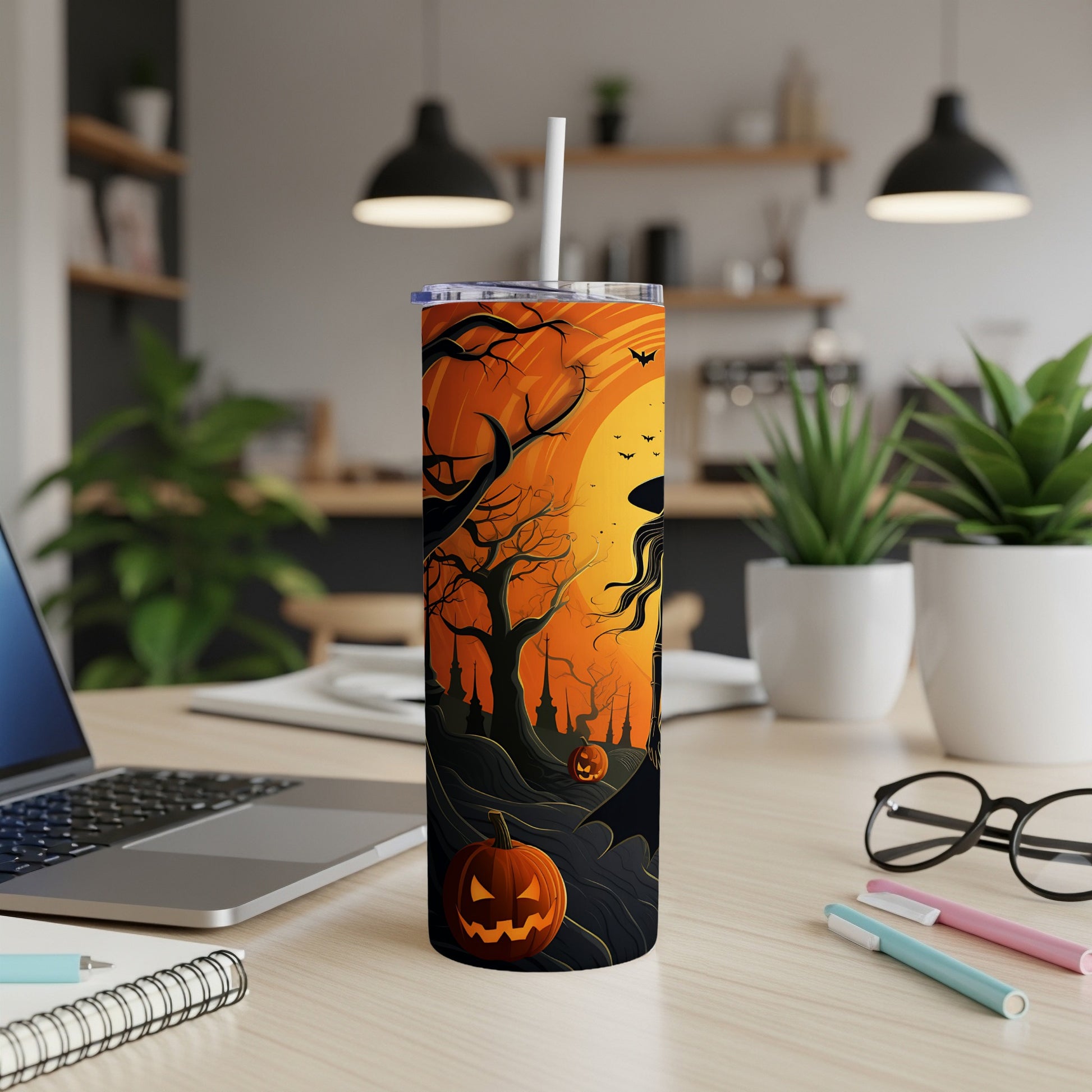 Halloween tumbler with witch, bats, pumpkins, and spooky trees on an orange sky.