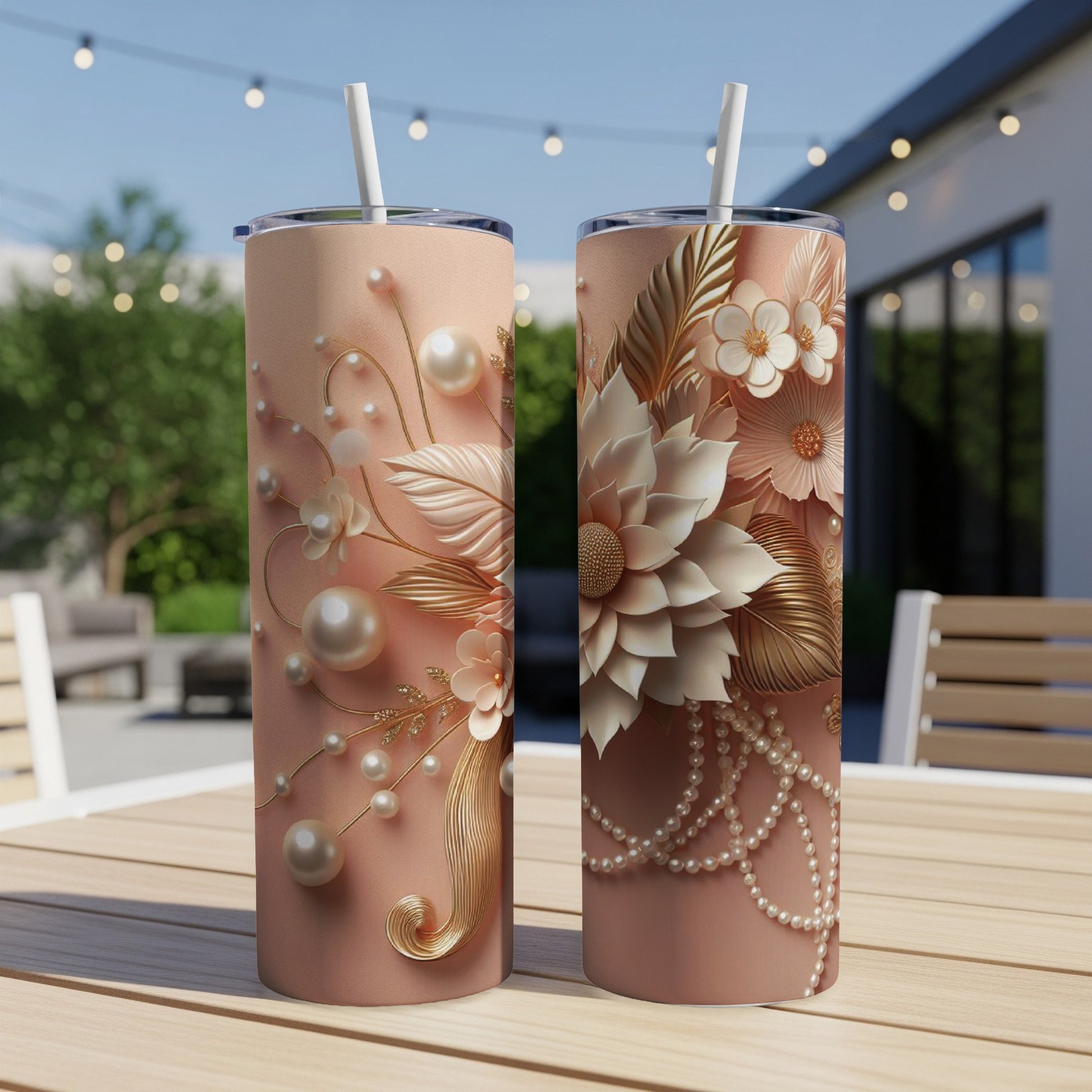 Two peach colored tumblers with floral and pearl embellishments on a wooden table.