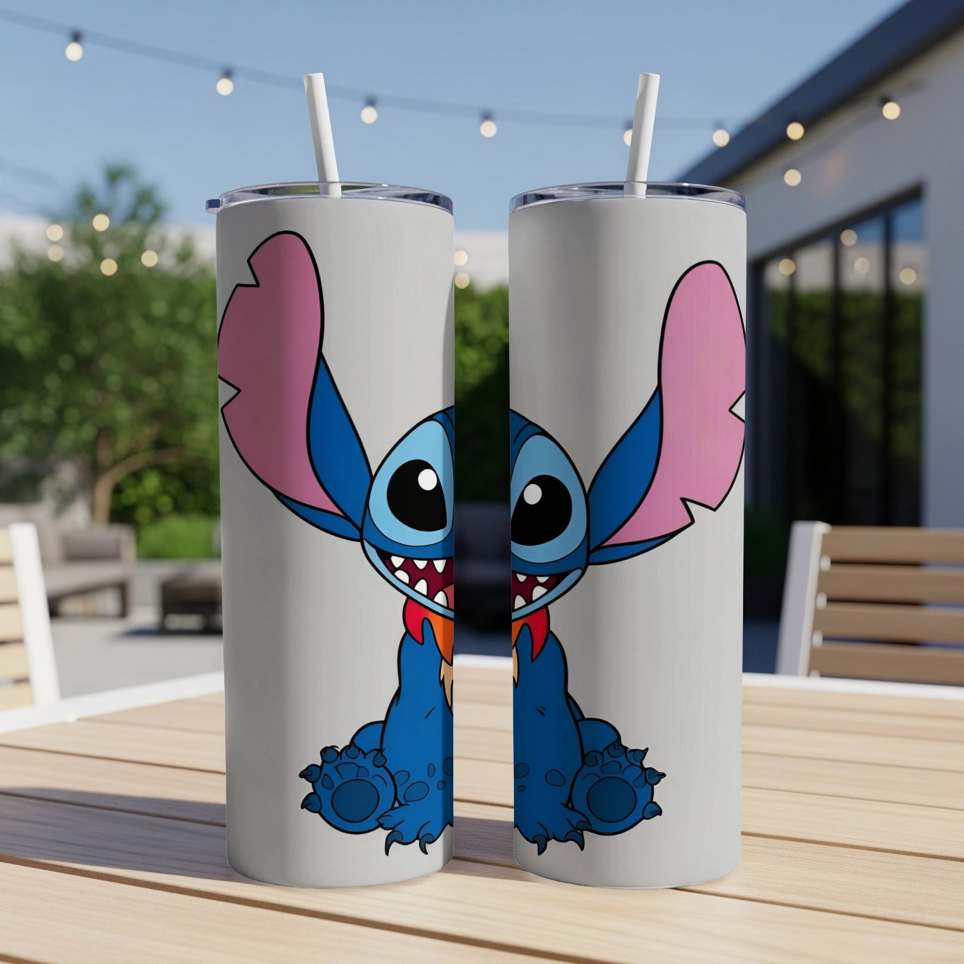 Two light grey tumblers with Stitch character design on a wooden table.