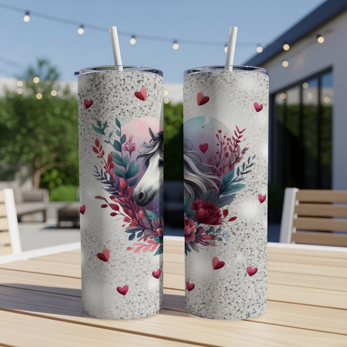 Two tall tumblers with a horse and floral design, set outdoors.