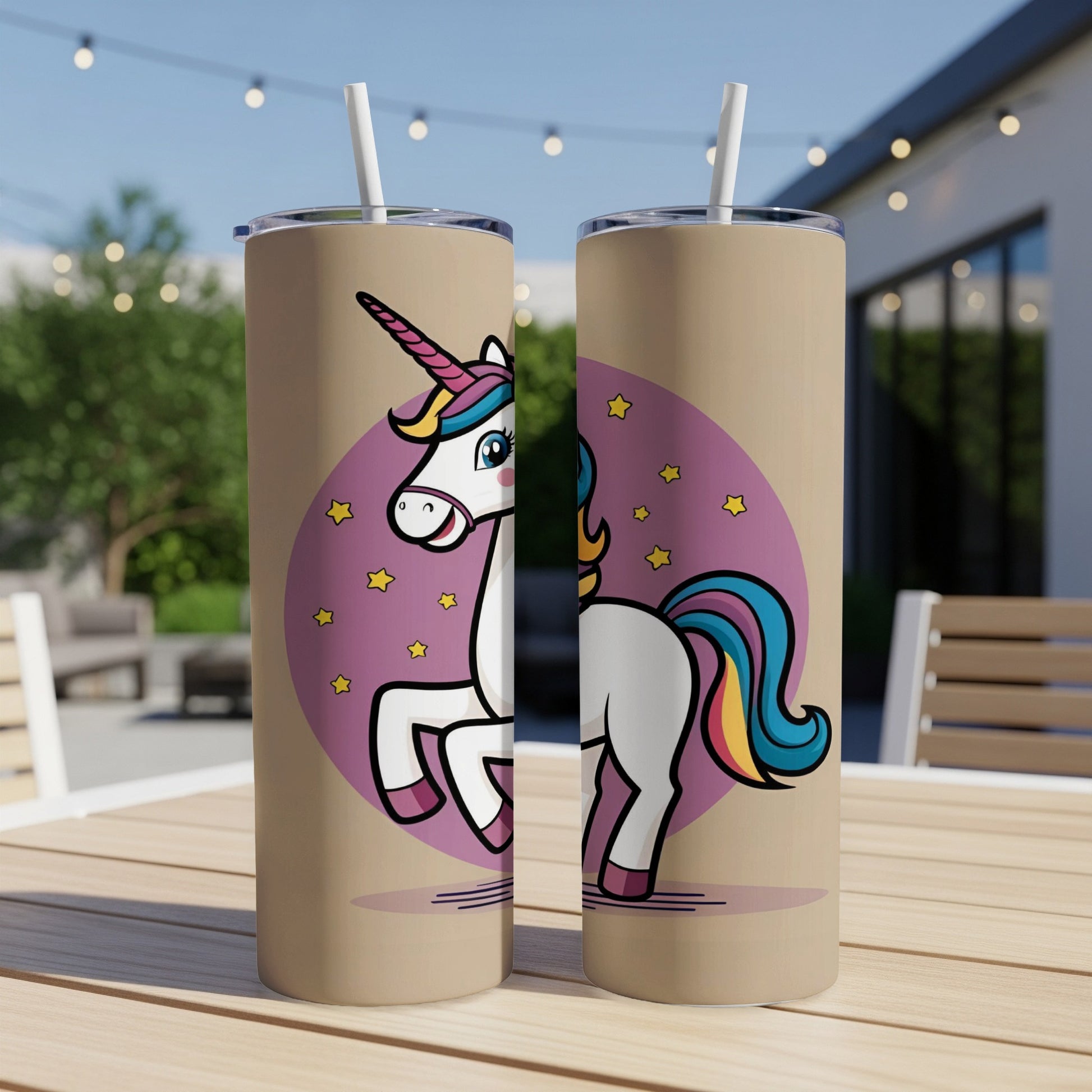 Two tall tumblers with a cartoon unicorn design on a table.