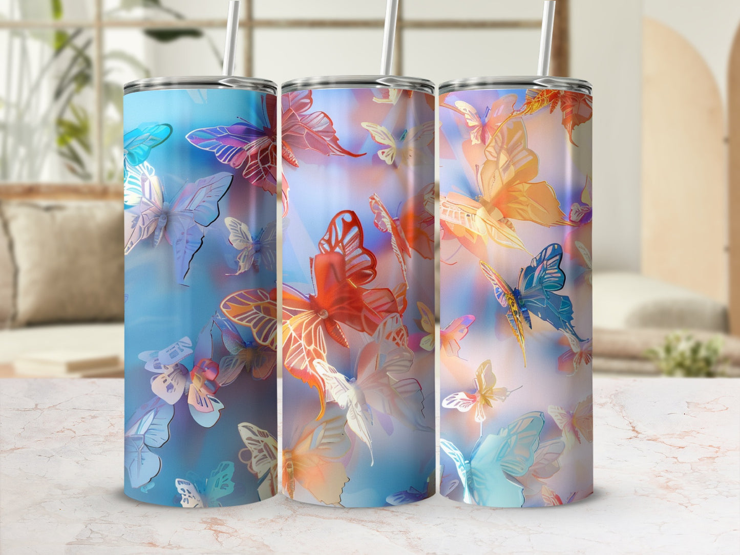 Three tumblers with colorful butterfly designs displayed on a counter.
