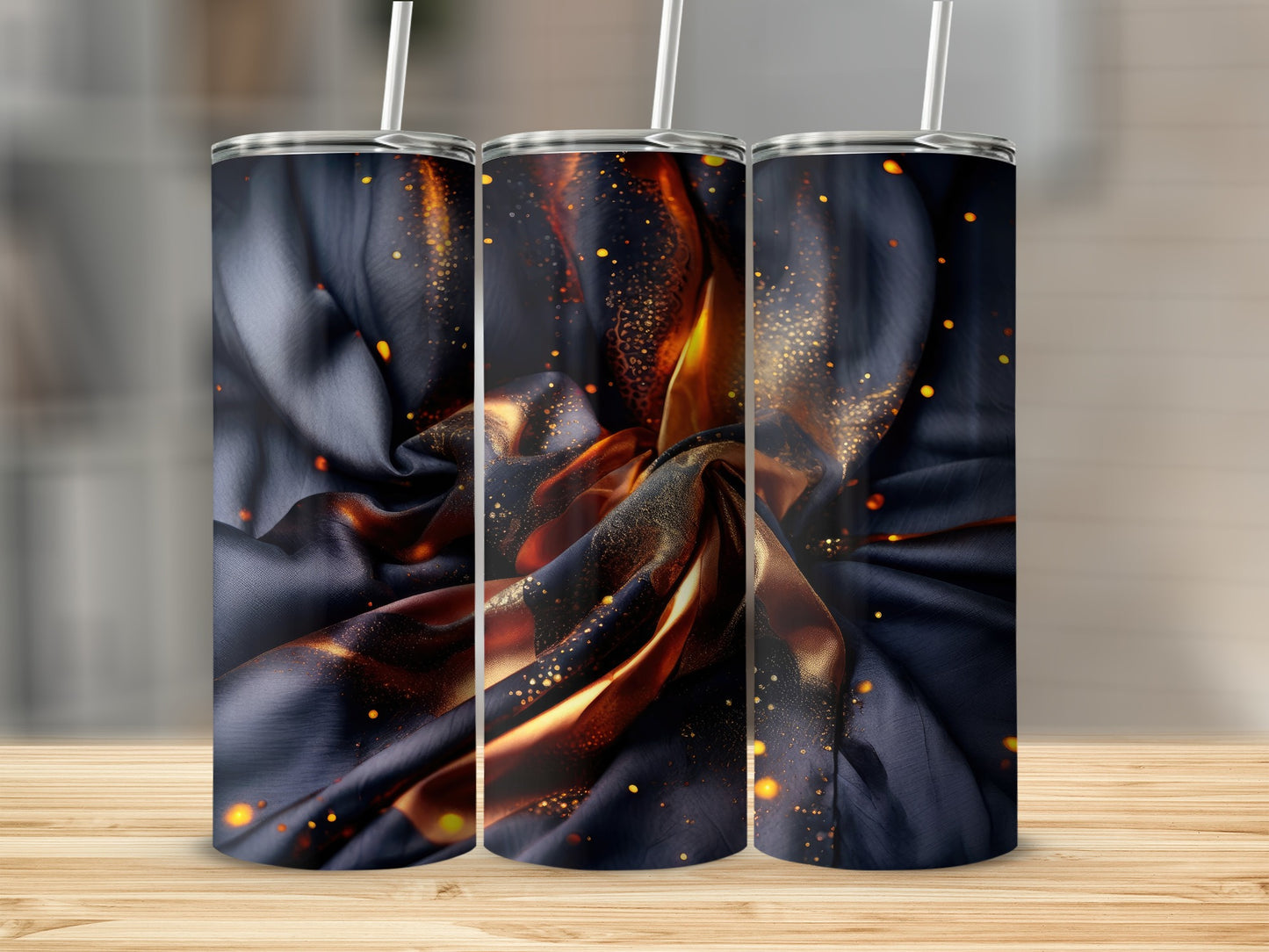 Three tumblers with dark satin fabric and glowing orange embers.