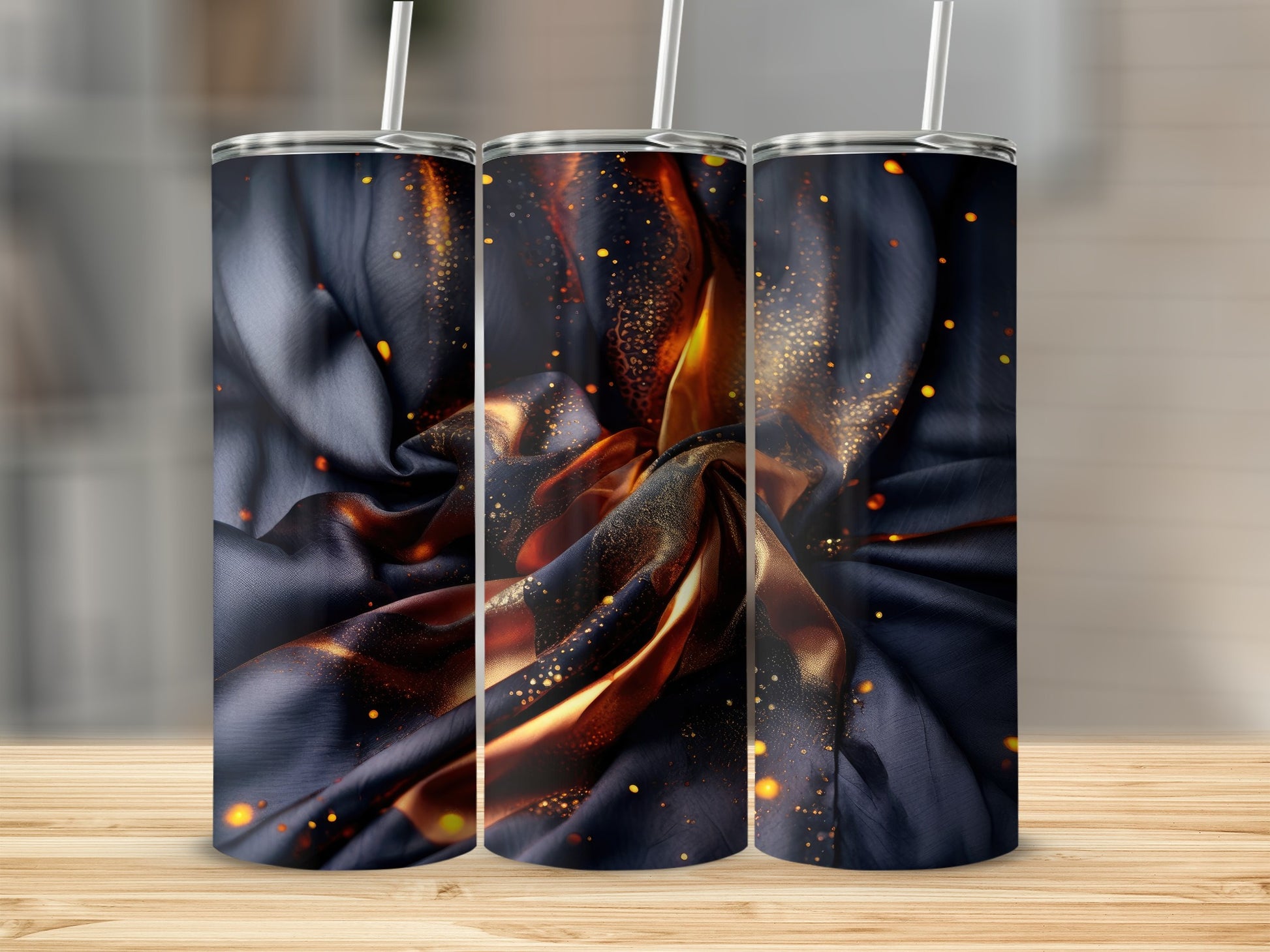 Three tumblers with dark satin fabric and glowing orange embers.