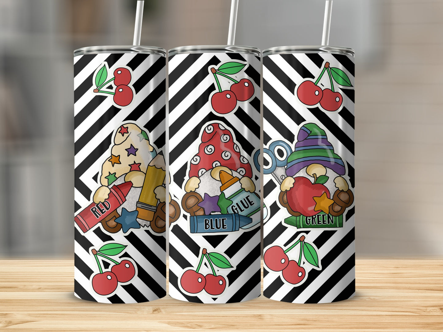 Three tumblers with gnome and school supply designs, including crayons and apples.