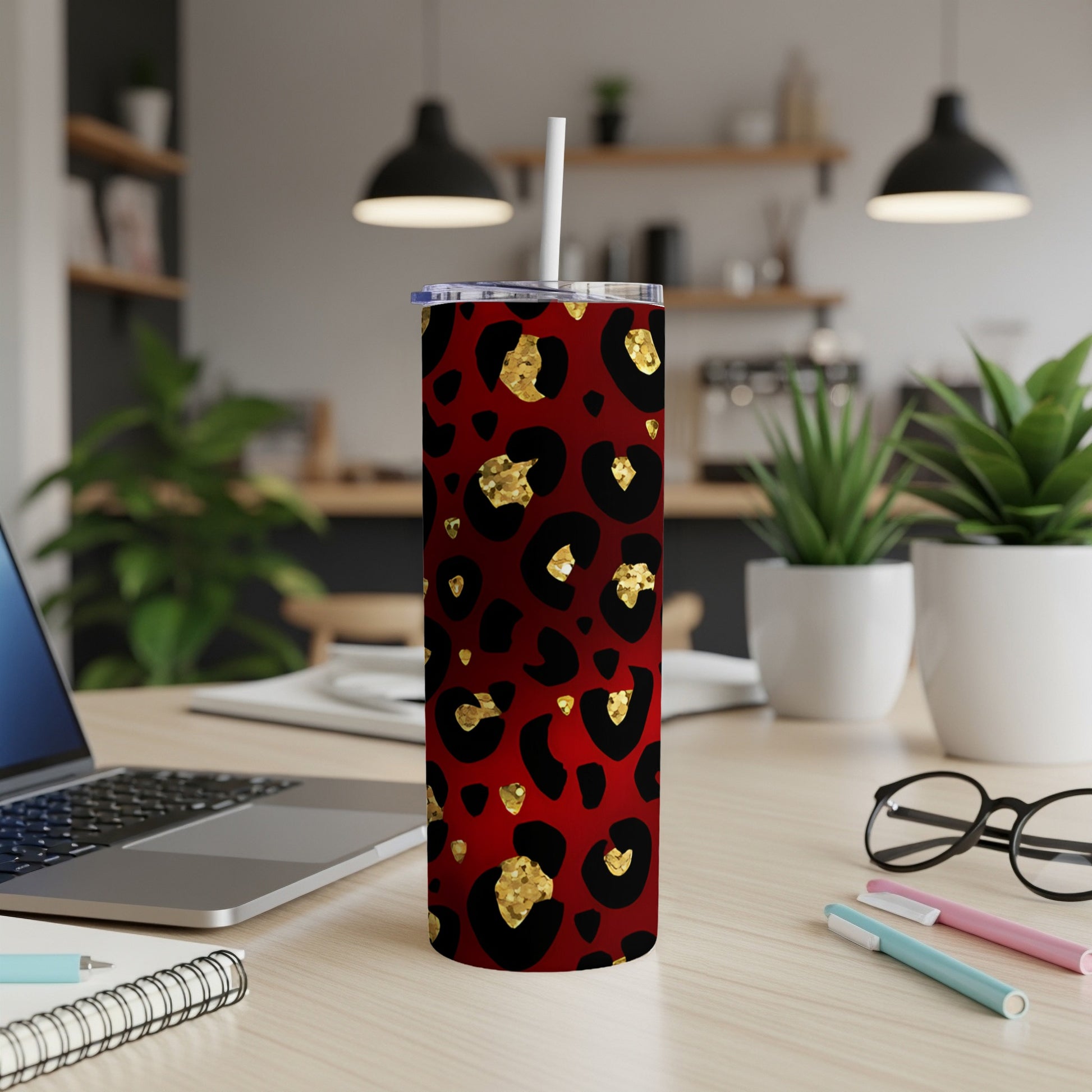 Red tumbler with gold and black leopard print, on a desk.