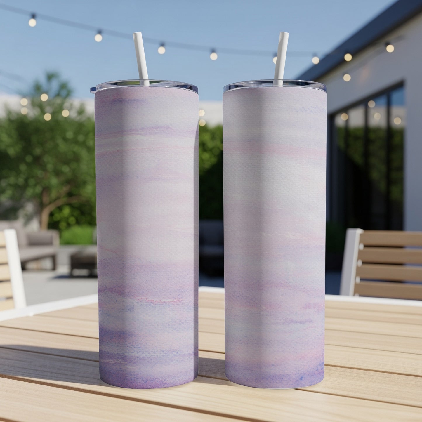 Two tall, slender tumblers with a pink and purple marbled design sit on a wooden table.