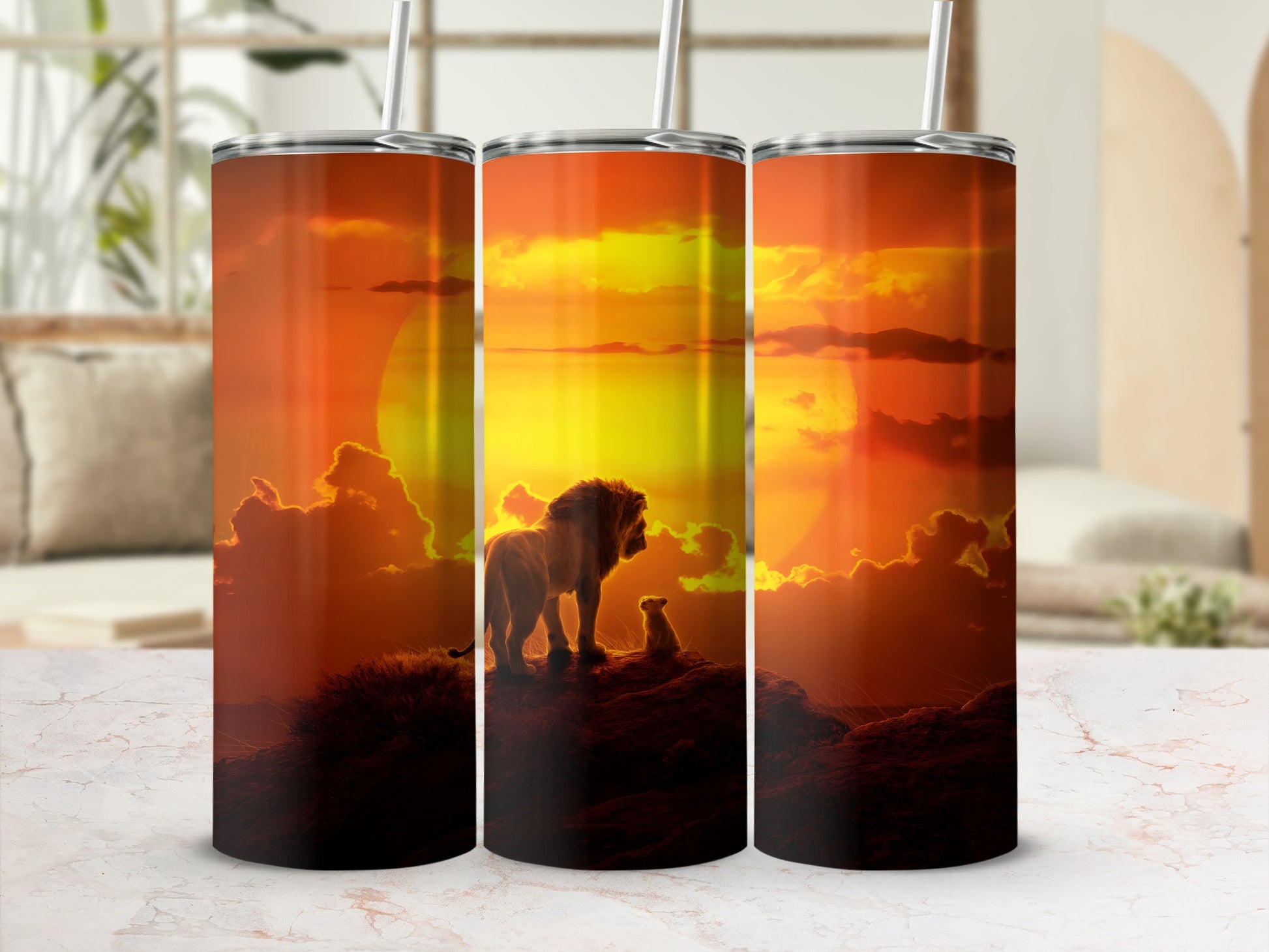 Three tumblers with a lion and cub silhouette against a sunset.