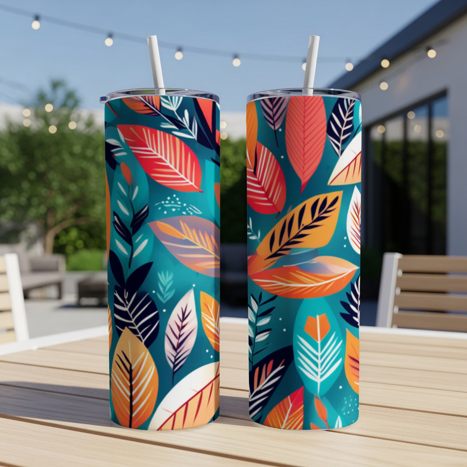 Two teal tumblers with vibrant coral, orange, and navy leaf pattern.
