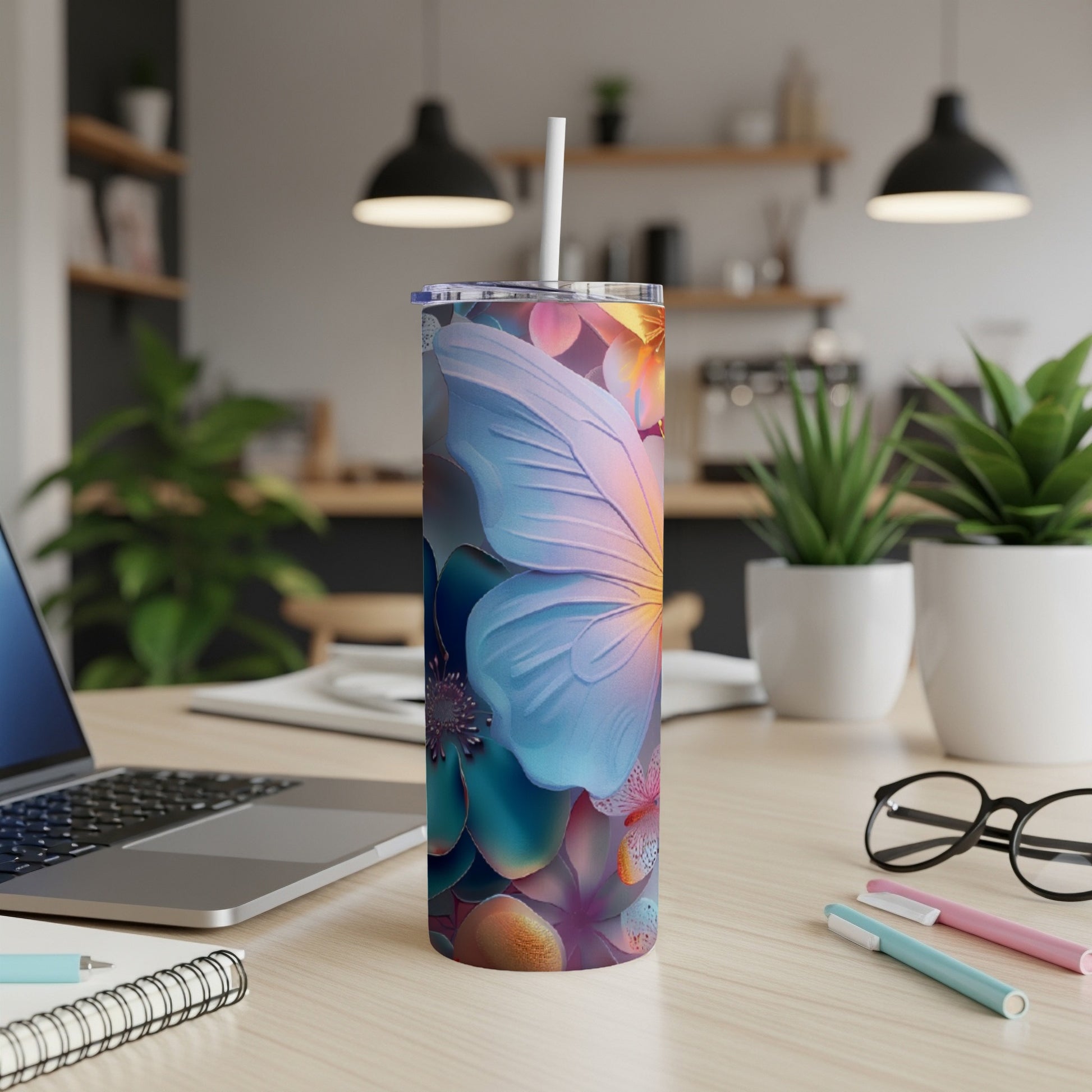 Tumbler with colorful butterfly and floral design on a desk.